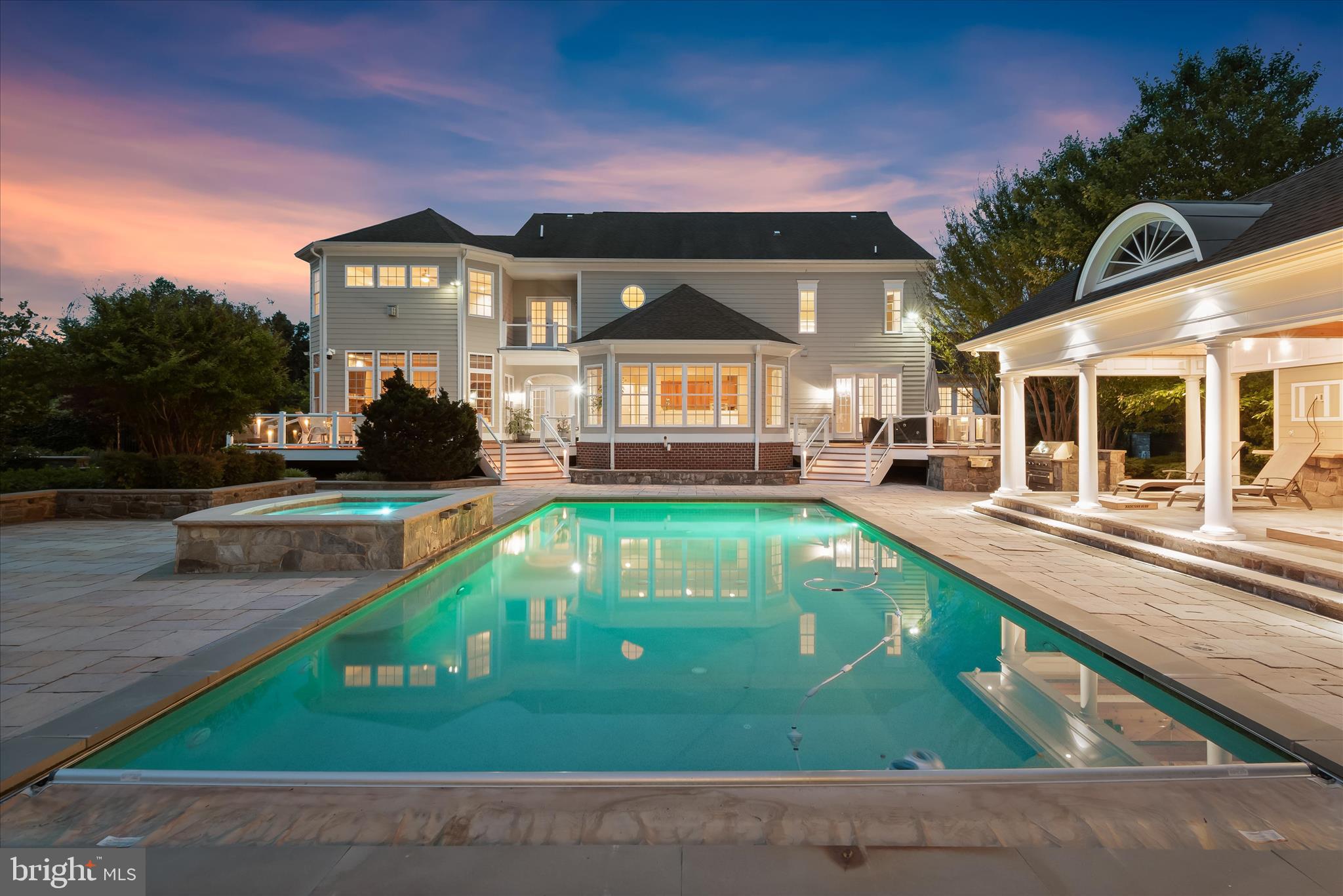 Welcome to 10130 Sycamore Hollow Lane, a magnificent custom-built estate by Mitchell & Best, elegantly situated on 2.07 professionally landscaped acres within the prestigious gated enclave of Long Meadow at Davis Mill. Blending timeless craftsmanship with sophisticated design, this exceptional residence offers an unparalleled lifestyle defined by luxury, privacy, and effortless indoor-outdoor living. The resort-inspired backyard serves as a private sanctuary, featuring a heated in-ground pool and spa, expansive custom stone patio, fully equipped outdoor grilling station, charming cabana, outdoor fireplace, multiple entertaining decks, and meticulously designed landscaping that creates a breathtaking setting in every season.
Inside, a grand two-story foyer sets an elegant tone and opens to formal living and dining rooms adorned with rich hardwood flooring, classic moldings, and sophisticated architectural details. A sun-filled sunroom offers a peaceful space to relax, while the gourmet chef's kitchen serves as the heart of the home. Thoughtfully designed for both everyday living and entertaining, the kitchen features granite countertops, decorative backsplash, under-cabinet lighting, a center island with breakfast bar and prep sink, sleek appliances, a walk-in pantry, and a spacious breakfast room with direct access to the outdoor oasis. Just beyond, the impressive family room is connected by a charming breezeway and showcases a fireplace, elegant tray ceiling, and a rear staircase leading to the upper level. A private office, powder room, laundry room, arrival center, and garage access complete the main level.
The upper level is anchored by an exceptional primary suite designed as a luxurious retreat. Hardwood floors, a tray ceiling, and a cozy fireplace create a warm and inviting atmosphere, while the spa-inspired en-suite bath features a soaking tub, walk-in shower, separate vanities, and two generous walk-in closets. A private sitting room with balcony access offers a serene escape overlooking the grounds. An additional bedroom enjoys its own en-suite bath and walk-in closet, while a third bedroom includes a private full bath and bonus area with a convenient laundry chute. Bedrooms four and five each feature walk-in closets and share a dual-entry full bath.
The finished lower level offers an impressive collection of spaces designed for recreation, relaxation, and versatility. Highlights include a spacious game room with a wet bar featuring granite countertops and breakfast bar seating, a media room, exercise room, studio with built-in shelving, bonus room, full bath, abundant storage, and ample space to accommodate a variety of lifestyle needs. Combining elegant interiors, exceptional craftsmanship, and unparalleled outdoor living, this remarkable estate delivers a luxury lifestyle in one of the area's most desirable settings.