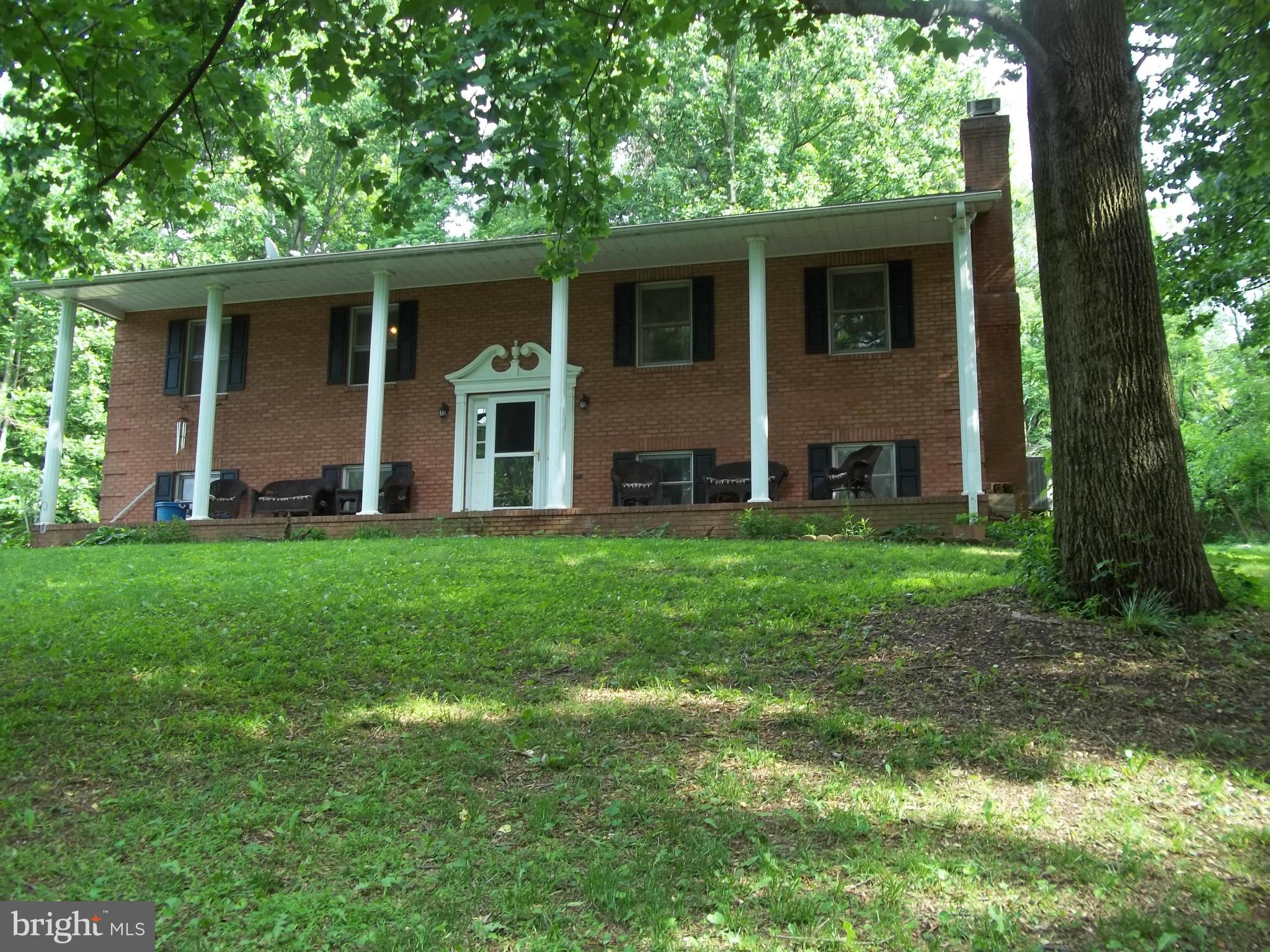 PRIVACY, SECLUSION &  NATURE ABOUND- on this almost 2.5 acre partly wooded parcel w/asphalt driveway &  hilltop country view.  All brick home features wood floors in formal dining rm w/access to extra large rear deck, formal living rm also w/wood floors plus brick wood burning fireplace, 3 generous  sized bedrooms, full master bath, LL family rm w/woodstove hookup, separate laundry & 2 car garage.