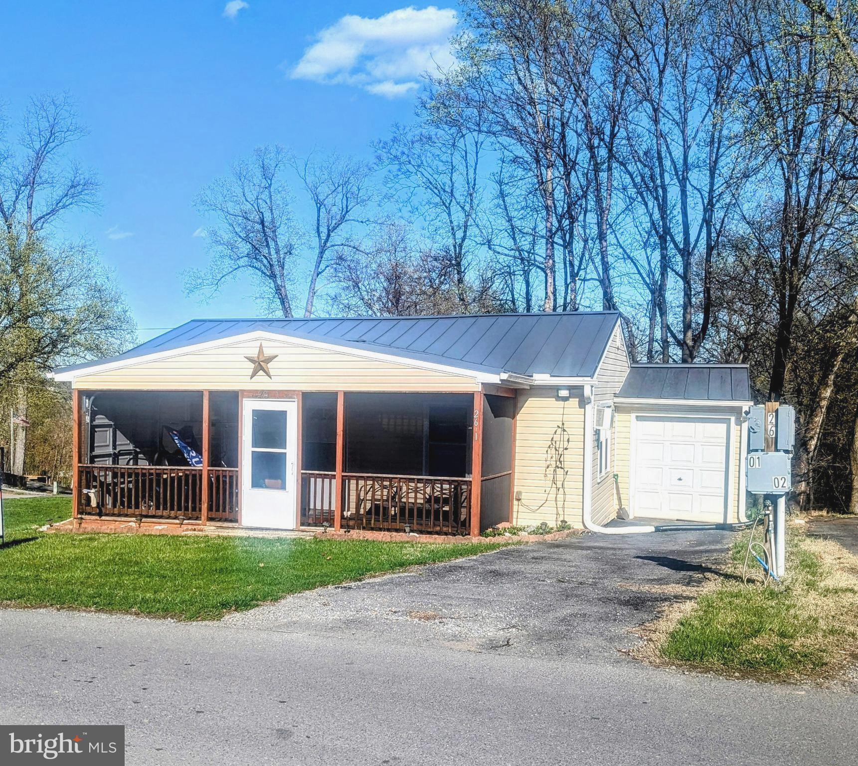 This property features two bedrooms, each offering ample storage space. The layout includes a comfortable living room, an eat-in kitchen, and one bathroom. A highlight of the home is the spacious screened-in front porch, perfect for relaxation. Additionally, there is a side garage that can accommodate a golf cart or other recreational items. The property is equipped with its own washer and dryer for added convenience.

Outside, you will find a large private patio, ideal for enjoying evening fires with friends and family or for a peaceful escape from daily life. This home is turn-key and ready for you to embrace the river lifestyle. Most furnishings and items are included with the property, with the exception of a few personal belongings.

This is a gated community, so you need to enter at the guard shack. Entry is not permitted without ID per the office rules. Bring IDs to the office or guard shack for visitor pass. THIS IS A SEASONAL CAMPGROUND! OPEN FROM APRIL 1 TO NOVEMBER 1. This lot is conveniently located for walking to the swimming pools, restaurant/lounge, mini golf, youth center, playgrounds and more. Large lot to enjoy time with your family & friends. River Bend is a privately owned 400 acre recreational- vehicle camp resort with seasonal activities for members, families and guests. Less than a 2-hour drive from the Washington and Baltimore metro area. Open with utilities from April 1 to November 1. Lot owners have access to their property the entire year. *** Members Enjoy *** * Amazing views and wildlife, Potomac River access, Trails, Swimming pools, Mini-Golf, Youth center, Tennis and basketball courts, laundry facilities, convenience store, deli and lounge. *Bath houses throughout the park, boat ramp, bar and grill and even a church located on the grounds. River Bend also hosts numerous activities such as 4th of July fireworks, small carnival, bonfires, poker runs, horseshoe tournaments, car show, Halloween Trick or Treat and so much more. The river is deep water for swimming, tubing and water skiing. CAN NOT LIVE HERE YEAR ROUND