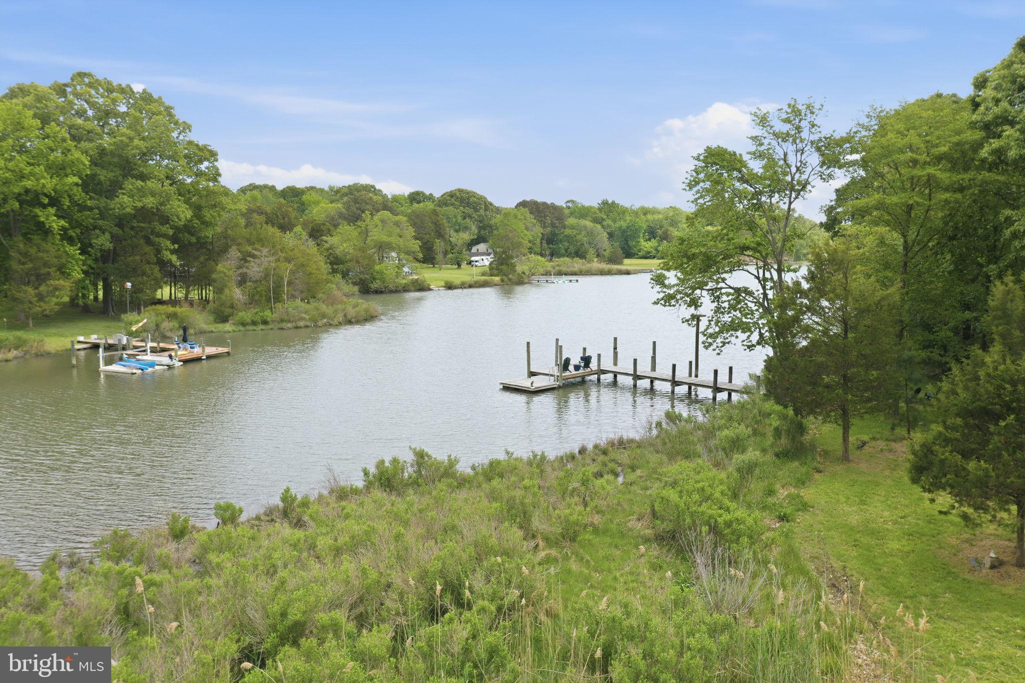 The Ultimate Private Waterfront Retreat on Carrs Creek

Tucked along the shoreline of Carrs Creek in the heart of Southern Anne Arundel County, 5865 Deale Beach Road is the kind of rare waterfront estate that feels worlds away without asking you to give up convenience. Set on nearly 14 private acres, this beautifully expanded and updated farmhouse blends Chesapeake charm, refined finishes, and the freedom of true country living—just minutes from the restaurants, marinas, and small-town energy of Deale, Galesville, and North Beach.

Inside, the home is warm, elegant, and designed for gathering. The spectacular kitchen pairs Viking appliances, white cabinetry, quartz countertops, generous island seating, and a statement light fixture with an easy flow into the family room, where an oversized stone wood-burning fireplace and walls of windows frame peaceful water views. It is the kind of space built for slow Sunday mornings, holiday dinners, and evenings that move effortlessly from the kitchen to the porch to the water’s edge.

The main-level primary suite offers a private retreat of its own, with sliding doors to the deck and hot tub, a large walk-in closet, and an elegant bath featuring a glass-enclosed slate shower and separate jetted tub. A spacious office and additional bedroom complete the main level, while the upper floor offers three more bedrooms, including an en-suite bedroom with its own private screened porch overlooking the creek.

Outside, the property becomes something truly special. Spend summer afternoons by the waterside pool, launch paddleboards and kayaks from your private pier and floating dock, gather around the fire pit after sunset, or practice your short game from the tee box. Screened porches, stone patios, open lawn, and wide water views create a lifestyle that feels equal parts luxury retreat and Chesapeake homestead.

For those craving space, privacy, and purpose, the grounds deliver. A fenced garden area with chicken coop, gardening shed, vegetable garden, and room to roam brings fresh eggs, homegrown vegetables, and a slower rhythm to everyday life. A large detached garage with a bathroom and second level is ideal for a car enthusiast, workshop, studio, equipment storage, or hobby space. A commercial whole-house generator adds peace of mind, keeping the property ready in every season.

Private, polished, and incredibly versatile, 5865 Deale Beach Road is more than a waterfront home—it is a full-scale lifestyle property. Whether imagined as a year-round residence, a weekend escape from the DC region, or a legacy retreat close to Annapolis, Joint Base Andrews, Northern Virginia, and the Chesapeake Bay, this is Southern Maryland waterfront living at its most complete.