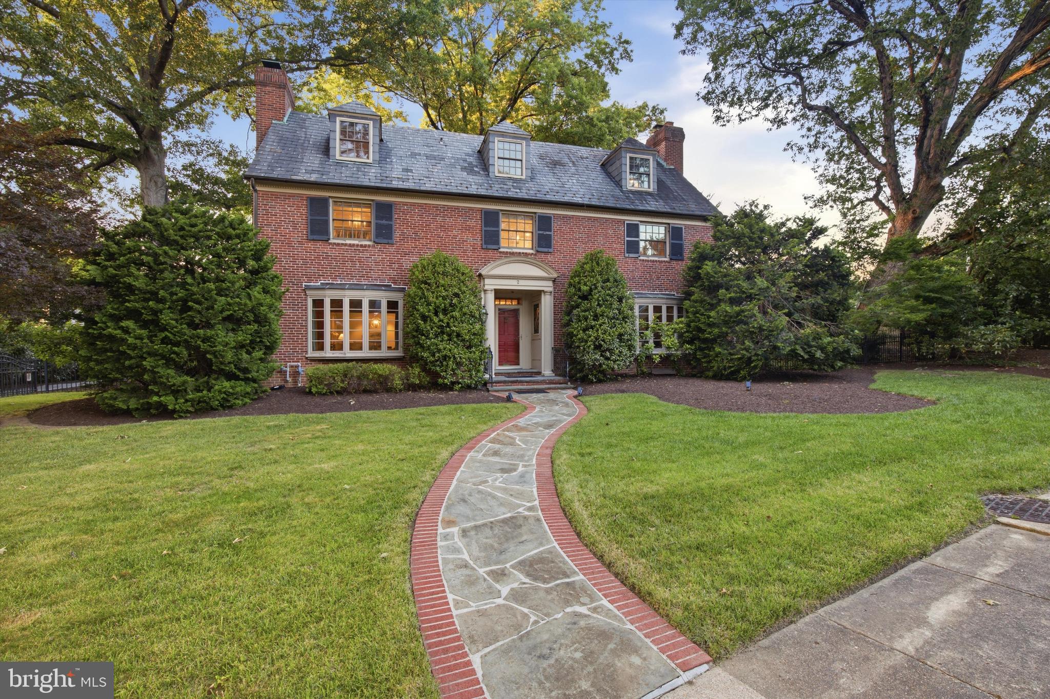 Exceptional all-brick Georgian Colonial offering five bedrooms, three full and two half baths, and over four finished levels of thoughtfully curated living space. A sweeping 2-story marble foyer with open oak staircase, Greek key crown molding, and a modern chandelier sets the tone for the craftsmanship found throughout.

The main level flows effortlessly from a formal Living Room with wood-burning fireplace and Colonial mantel to a gracious Dining Room with box bay window and custom built-in window seat, to a cherry-paneled Den with its own fireplace — each space finished with hardwood floors, dentil crown molding, recessed lighting, and built-in ceiling speakers. A Wet Bar with marble tops, illuminated glass-door cabinetry, Marvel wine cooler, and Scotsman icemaker connects seamlessly to the Living Room and Kitchen.

The Gourmet Kitchen is a chef's dream: Brookhaven recess-panel custom cabinetry, statuary marble counters, ceramic tile backsplash, Blue Star commercial-grade 6-burner gas range with double ovens and grill, Vent-A-Hood custom stainless range hood,  dishwasher, refrigerator, and an oversized undermount sink with Insinkerator disposal. The adjoining Breakfast Room features a vaulted ceiling, window wall, French door to the patio, and a built-in illuminated glass-shelved bookcase — a warm and light-filled gathering space.

Upstairs, the Master Suite offers four windows, crown molding, and direct access to a stunning Spa Bath with marble finish porcelain tile, freestanding soaking tub, glass-enclosed herringbone marble shower, matching granite-top vanities, and a built-in toiletries niche — plus a dedicated Dressing Room with extensive custom built-in wardrobe cabinetry and  honed granite island. Four additional generously sized bedrooms and two gorgeous baths — including a shared marble bath with soaking tub and herringbone shower — complete the upper levels, along with a Third Floor Study with staircase access to Bedrooms 4 and 5.

The Lower Level is an entertainer's haven: a sprawling Recreation Room with wood-burning fireplace, built-in seating with custom cushions, arts & crafts counter, built-in bookcases, and two mounted TVs — alongside a Wine Room with custom racks holding up to 500  bottles and a dedicated decanting counter.

Outside, enjoy a large brick paver patio with garden wall and brick seating surround, a flat fenced backyard with specimen tree, a partially covered front porch with classic Georgian doorcase, a brick-bordered stone walkway, a slate roof with dormers, and Pella replacement windows throughout. A 2-car garage, a secured rear parking pad, complete this extraordinary offering.