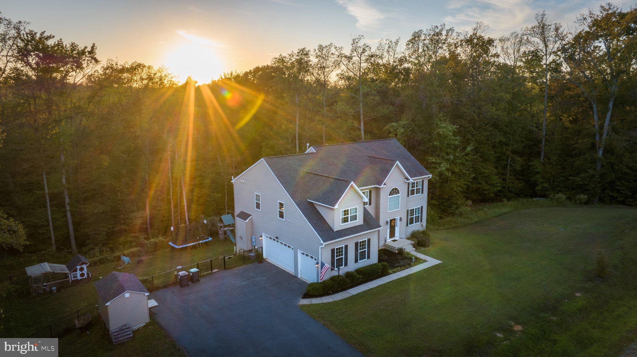 This gorgeous luxury homestead on 4+ acres is here! Welcome home to 2225 Camp Geary Lane in Stafford County, tucked away near Crows Nest natural preserve, and Aquia Landing and conveniently close to the Brooke VRE station for all points north. This beautifully built 5-bedroom, 4.5-bathroom home is perfectly situated on 4 private acres with multi-generational appeal and a homestead feel. Built in 2017, this thoughtfully crafted residence offers over 4,700 square feet of finished space, complete with beautiful hardwood floors on the main level, a dedicated home office, and multiple living areas ideal for family life and entertaining. Even better, this home has an assumable 2.5% VA loan. Call for details!

The main level features a formal living and dining room, a spacious family room with a gas fireplace, and a well-appointed kitchen equipped with a gas range and ample cabinetry. Love a pantry? You’ll love this one! The open and light-filled kitchen leads out into the generously sized deck with gazebo cover and a view of the chicken coop, play set, trampoline, tree-jungle gym, and fire pit seating area. Don’t worry, it’s all fenced in with a gorgeous wrought iron secure fence all the way around! 
Upstairs, the luxurious primary suite includes a cozy sitting area, another sitting area nook (or home gym?) an en-suite bath, and a large walk-in closet. Two additional bedrooms are connected by a Jack and Jill bathroom and a 4th bedroom with an adjacent full bath.
 A fully finished walk-out basement offers a complete in-law suite with 5th bedroom (NTC), full bathroom, recreation room and game space, perfect for extended family or guests. Storage galore!

Outside, the property is equally impressive. Enjoy your mornings or evenings on the expansive deck with a covered gazebo, or unwind around a crackling fire. Children and guests will love the on-site playground, trampoline, and jungle gym. A chicken coop adds a charming homestead touch, while a shed and RV parking provide practical storage solutions. The home also includes a side-load, three-car garage with ample driveway space.

This property offers a rare combination of space, functionality, and recreation—all within a peaceful, natural setting. It’s the perfect opportunity for anyone seeking a private retreat with modern amenities and room to grow.