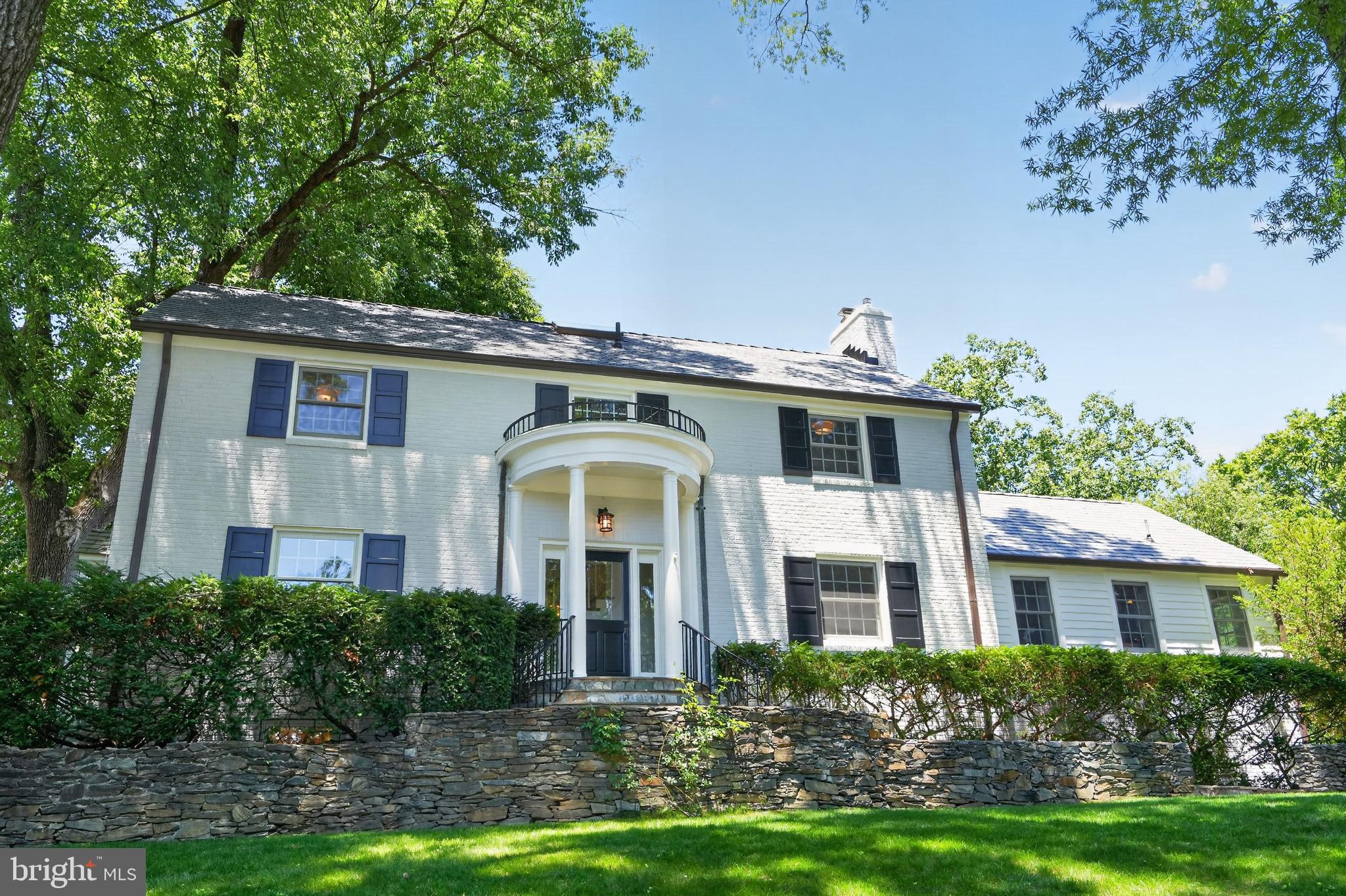 On coveted Palisade Lane in Kent, this classic five-bedroom Colonial presents a refined opportunity in one of Northwest Washington's most established neighborhoods. Set atop the highest point on a quiet, tree-lined cul-de-sac street, the residence pairs  timeless architecture with a comfortable and well considered floor plan.

At the center of the home is a gracious open kitchen, appointed with a professional grade Thermador range and Viking refrigerator, generous cabinetry, and expansive work surfaces. A large sun-drenched breakfast room adjoins the kitchen, offering a bright setting for informal dining, while a dedicated mud room adds everyday practicality and organization. The kitchen opens seamlessly into the main living room, anchored by a two-sided fireplace, creating an effortless flow for both daily living and entertaining. A spacious dining room comfortably seats eight or more guests, and a handsome library, complete with built-in shelving and a second fireplace, provides an inviting space to read, work, or unwind.

Hardwood floors extend throughout, lending continuity and a sense of enduring quality, while the two fireplaces bring warmth and architectural character to the principal living spaces. Abundant windows fill the home with natural light and frame views of the surrounding landscape.

The second-floor features three bedrooms, including the primary suite, offering a comfortable and private retreat. The top floor provides a fourth bedroom, well suited to a guest room, home office, or quiet getaway. The walk-out lower level adds a fifth bedroom and full bath, along with flexible space ideal for a media room, fitness area, or recreation room, with direct access to the rear grounds. In total, the home offers three and a half baths.

The two-car garage delivers everyday convenience and additional storage, while the .24-acre lot affords privacy and a tranquil outdoor setting close to the city's amenities. The property sits just minutes from Spring Valley shopping, distinguished schools, neighborhood parkland, and downtown.

Move-in ready and thoughtfully appointed, this is an exceptional opportunity to own a beautifully maintained Colonial on one of Kent's most sought-after streets.