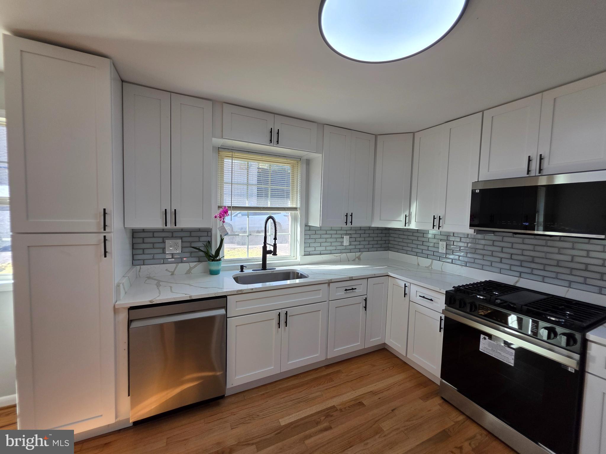 Fully renovated, hardwood floors on top 2 levels. New vinyl plank flooring in family room. New ceramic Italian tile in bathrooms. New bathroom vanities, new plumbing  fixtures throughout. Kitchen has new: Samsung stainless steel appliances, new quartz counter tops and new kitchen cabinets. Rear patio off family room. 1 car garage. 2 fireplace's 1 in living room and and  family room. Fenced rear yard.