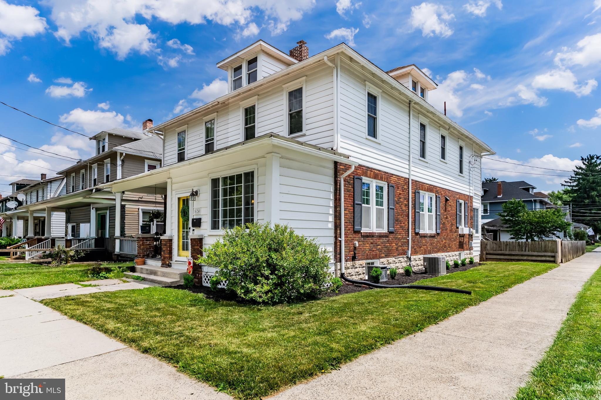Welcome home to this charming and meticulously maintained early-1900s home situated on a desirable corner lot in New Cumberland Borough, directly across from Memorial Field and within walking distance of Hillside Elementary, local shops, restaurants and the newly revitalized West Shore Theatre. Exceptional curb appeal shines with classic brick and stone exterior accents, beautiful landscaping, and inviting outdoor living spaces. The fully fenced backyard offers the perfect setting for entertaining and everyday enjoyment, featuring a deck, brick patio and walkways, pergola, and plenty of grassy space for play. A detached one-car garage provides excellent storage for bicycles, motorcycles, lawn equipment, outdoor gear, or workshop space. Step inside through the fully enclosed front porch and into a bright, open-concept living and dining area filled with natural light. Rich hardwood floors, a stunning statement staircase, original built-ins and timeless architectural details showcase the character and craftsmanship of this special home. The kitchen offers ample paintable cabinetry, stainless steel appliances, a built-in microwave, brand-new GE dishwasher, double-bowl porcelain sink with gooseneck faucet and a Waterdrop water purification system. A convenient main-level half bath, mudroom, and laundry room add everyday functionality. Upstairs, the primary bedroom features gleaming original hardwood flooring, overhead lighting, and a ceiling fan. Two additional bedrooms provide flexible space for family, guests or a home office. The second-floor enclosed balcony offers a cozy retreat, while the hall bath features a modern vanity, porcelain tub, and tile surround. Additional highlights include a third-floor attic perfect for storage, a basement with utility sink and even more storage space, newer windows, fresh paint and recently installed central air conditioning. Lovingly cared for by its current owners, this move-in ready home combines historic charm with modern comfort - nothing left to do but unpack and enjoy.