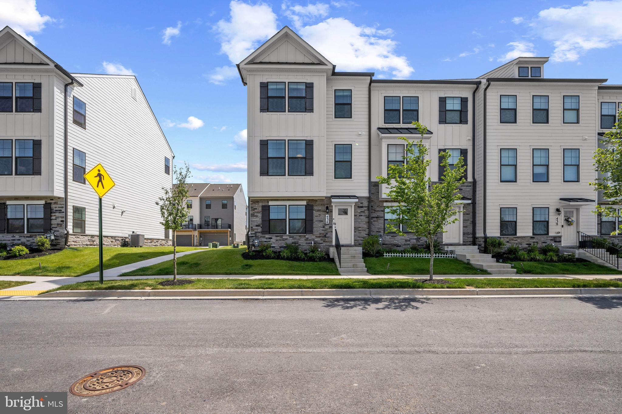 Beautifully appointed end-of-row townhouse residence, newly built in 2024, offering 4 bedrooms, 3.5 bathrooms, and 2,088 finished square feet in a prime high-elevation location within Frederick's highly sought-after Renn Quarter community. // The entry level welcomes you with a spacious foyer, access to the attached 2-car garage, a private bedroom, and a full bathroom, creating the perfect setup for guests, a home office, or multigenerational living. // Ascend to the sun-filled open-concept main level, thoughtfully designed for both everyday living and entertaining. This inviting space features a spacious living room, a convenient powder room, and a dining area with balcony access for seamless indoor-outdoor living. // The stylish eat-in kitchen is the heart of the home, showcasing an oversized island with breakfast bar seating, stainless steel appliances, a classic subway tile backsplash, a pantry, and ample cabinetry and workspace. // Upstairs, plush carpeting continues throughout three generously sized bedrooms, a centrally located laundry closet, and two full bathrooms. The serene owner's suite offers a ceiling fan, a walk-in closet, and a private ensuite bath complete with a dual-sink vanity and a glass-enclosed shower. // Residents enjoy an exceptional lifestyle with access to Renn Quarter's resort-inspired amenities, including a community pool with a children's area and a fitness center. The community is also adjacent to the newly approved 78-acre FCPC park and the future Carroll Creek Park walkway extension. Just minutes from award-winning Downtown Frederick, you'll enjoy a vibrant blend of historic charm, locally owned restaurants, boutique shopping, entertainment, scenic Appalachian Mountain views, nearby access to the Monocacy River and Carroll Creek, and convenient commuter routes including I-70, I-270, Route 40, Route 144, and Route 15.