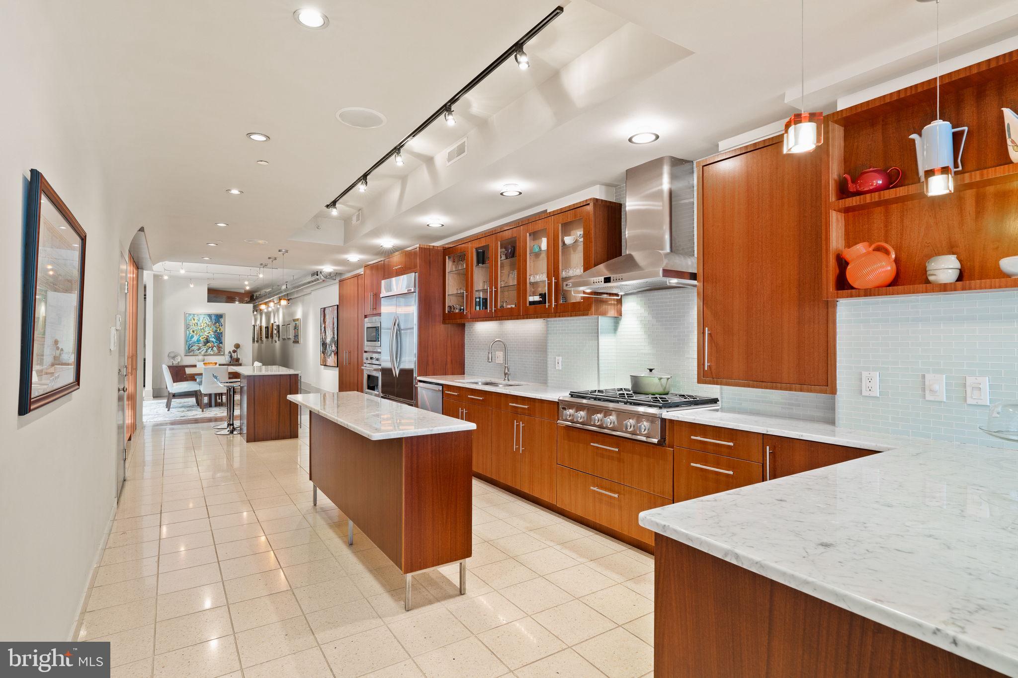 Refined single-floor living awaits in this masterfully curated, architecturally distinctive second-floor residence at 1606 Chestnut Street. Spanning approximately 2,500 square feet, this exceptional residence features a rare, elongated layout designed for effortless flow between multiple living and entertaining spaces. Every detail reflects a commitment to craftsmanship and design, with bespoke custom cabinetry and thoughtfully integrated built-ins throughout. The open and airy 19-foot wide living room is a true showpiece, highlighted by 9.5-foot ceilings, exposed brick and oversized bay windows flooding the space with natural light. At the heart of the residence is a remarkable 32-foot chef’s kitchen, impeccably designed with striking custom cabinetry, premium appliances, and elegant terrazzo tile flooring. Two center islands provide approximately 13 feet of counter space, making the kitchen ideal for entertaining, casual gatherings, and everyday cooking. Abundant built-in storage completes the space, seamlessly blending style and functionality. The formal dining area comfortably accommodates eight guests and is enhanced by a luminous light well, introducing an elevated architectural element and natural ambiance. Beyond, a spacious den and study with custom wood ceilings offer a rich, intimate setting ideal for relaxation or flexible work-from-home living. An integrated office nook provides a refined and functional workspace while preserving the room’s warmth and character. The primary suite is a private sanctuary, complete with dual walk-in closets and a spa-caliber en-suite bath featuring custom millwork, double vanities, a water closet and an oversized rain shower designed for ultimate relaxation. Currently configured as an expansive one-bedroom residence, the home offers the flexibility to seamlessly convert the den into a true second bedroom (reference the proposed layout in photo gallery) A thoughtfully designed floor plan is available for review in the photo gallery. Originally built in the 1890s by Isaac S. Miller and designed by architect Albert W. Dilks, 1606 Chestnut Street was notably advanced for its time, featuring two elevators and a central skylight that allows natural light to filter through the building. The interiors were crafted by master woodworker Francis D. Kramer, the building’s first tenant.. Ideally located just two blocks from Rittenhouse Square, this residence places you in the heart of Philadelphia’s most sought-after neighborhood, surrounded by renowned dining, boutique shopping, and vibrant city life. This address offers an elevated urban lifestyle where everything you desire is just steps from your door. One storage locker included in the sale. * REAL ESTATE TAXES ARE OVERASSESSED