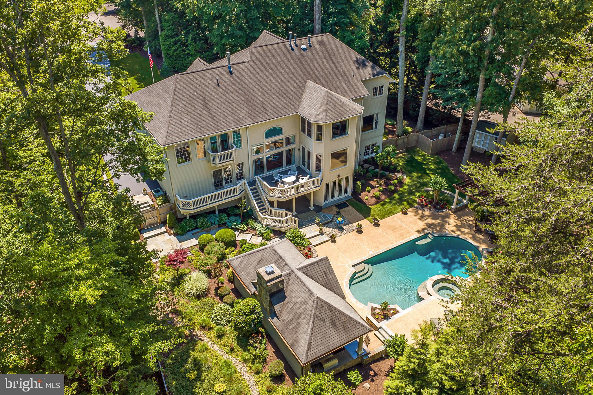 Exceptional and truly one-of-a-kind, this Fairfax Station estate offers more than 7,000 square feet of refined living, unmatched upgrades, and resort-style outdoor spaces. With over $1.5 million invested in renovations since purchase, this rare property shows like a model and delivers an extraordinary blend of elegance, comfort and flexibility. ***** The main residence features an open, light-filled floor plan with beautifully updated interiors, including newer interior paint, rich hardwood flooring, extensive custom moldings and Amish-built custom cabinetry. Elegant formal living and dining rooms create a sophisticated setting for gatherings, while the expansive family room opens seamlessly to the remodeled chef’s kitchen for effortless everyday living and entertaining. The kitchen is appointed with a Wolf range, Samsung French door refrigerator, wine fridge, granite countertops, and a beautiful connection to the stunning two story family room with a statement fireplace and stone detail ****** The upper level offers four spacious bedrooms and three full baths, including a luxurious primary suite with a sitting area, romantic fireplace, two walk-in closets, and a fully remodeled spa bath. A private princess suite and a Jack and Jill bathroom complete the upper level. The fully finished walkout lower level is truly exceptional, featuring high-end flooring, custom Amish millwork, built-in gas lanterns, and a designer wet bar with granite countertops, an additional refrigerator, and a dishwasher. A dedicated wine room, full bath with steam shower, private gym, and pool changing room add both function and sophistication creating a lower level designed for relaxation, entertaining, and everyday enjoyment. ****** Outdoor living is just as impressive, with beautifully designed grounds enhanced by high-end LED low-voltage lighting and a Wi-Fi controlled irrigation system. The backyard oasis features an in-ground pool with heated spa, expansive slate and concrete hardscaping, and a fully equipped outdoor kitchen with dual refrigerators, fireplace, ceiling fans, and generous dining and entertaining areas designed for year-round enjoyment. ****** A standout feature of the property is the attached addition with an additional 5th full bath, offering incredible flexibility as a club room, private office, guest suite, multigenerational living space, or potential income-producing opportunity. The expanded four-car garage is a car enthusiast’s dream, complete with separate heating and cooling, recently resurfaced epoxy floors, and custom built-ins, and abundant. Additional highlights include a newer 75-gallon hot water heater installed in 2020, a freshly painted exterior, updated interior paint, and a newer fence. Rarely does a property offer this level of space, quality, thoughtful renovation, and resort-style living in such a coveted Fairfax Station setting.
