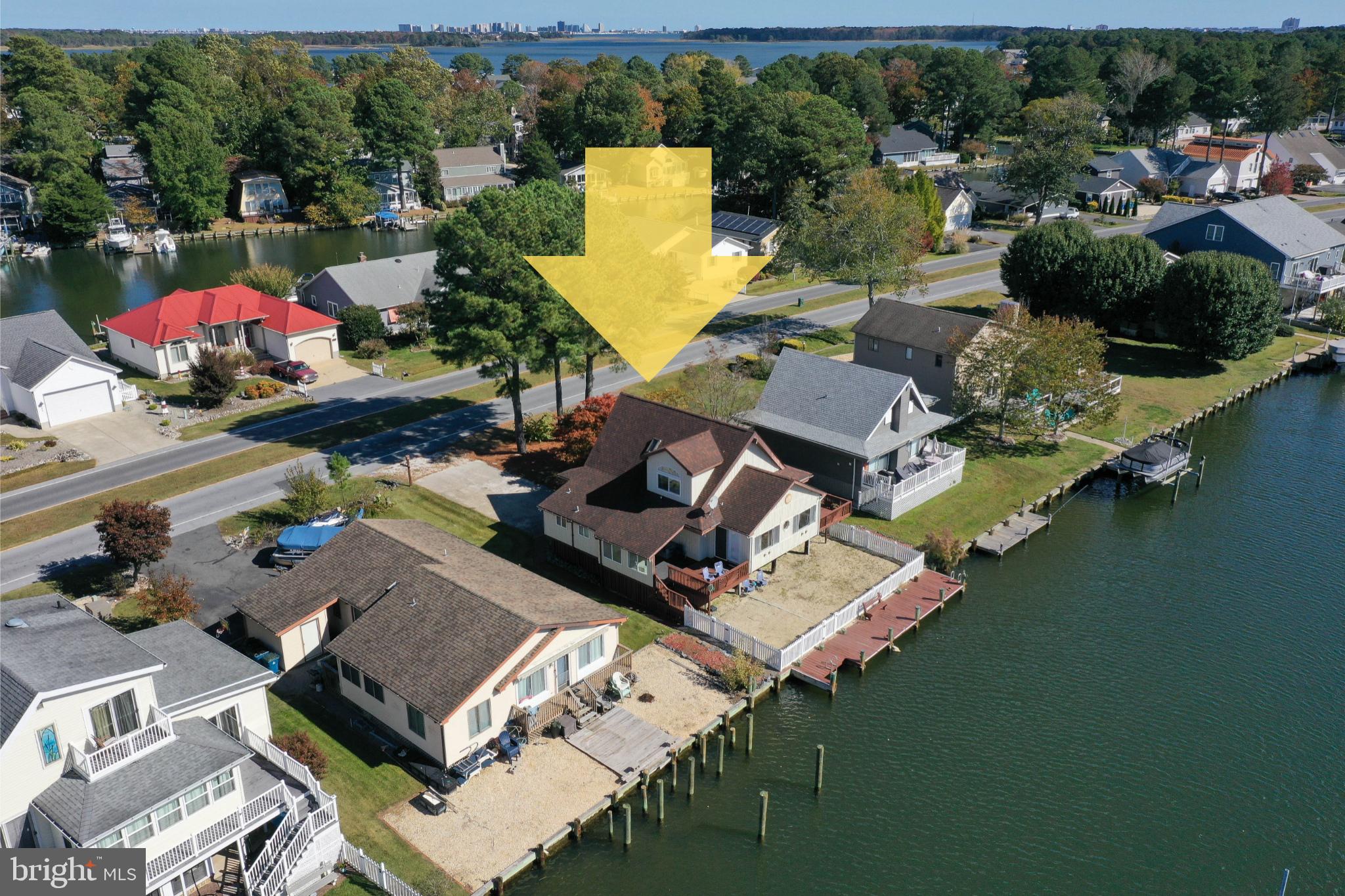 WATERFRONT beach retreat with recent updates! Welcoming, light + airy contemporary with a great rental history [approx $49,000/year] on a wide, deep-water canal w/private pier - located in incredibly amenity-rich Ocean Pines - multiple parks + pools, marinas, boat launches, beaches, robust recreation programs, walking trails, golf, yacht club, and so much more - just 5 miles from Ocean City, where OP residents have an oceanfront Beach Club. BBQ or laze the day away on your own 'sandy beach' in your fenced backyard overlooking the water. Enjoy 'second season' on the covered porch. Inside - tons of room to roam - and plenty of spots to sleep!  Living room w/new LVP flooring, vaulted ceiling, decorative/exposed beams, opens into the kitchen. Bright and cheery kitchen with new fridge, new LVP floor. Formal dining room seats a houseful and boasts a new LVP floor. One Primary bedroom with attached bath is on the 1st floor + features an attached office / flex room currently housing bunk-beds. Bedroom 2 is also on the 1st floor. Upstairs, an additional primary bedroom w/ full, en-suite bathroom, + a loft area large enough to be a guest room. HOA is $1,515/year for bulkheaded waterfront lots - and with all the neighborhood amenities, you can vacation at home all year long, minutes to fishing and pony-watching at the treasure that is Assateague Island; spend an afternoon on Ocean City's boardwalk. Shopping, dining, arts, history, and tons of entertainment - from nature walks and water sports to tennis and everything in between. Visit Downtown Berlin to enjoy a rich arts scene, unique boutiques, museums, breweries, restaurants - it's America's Coolest Small Town after all! Sizes, taxes are approximate.