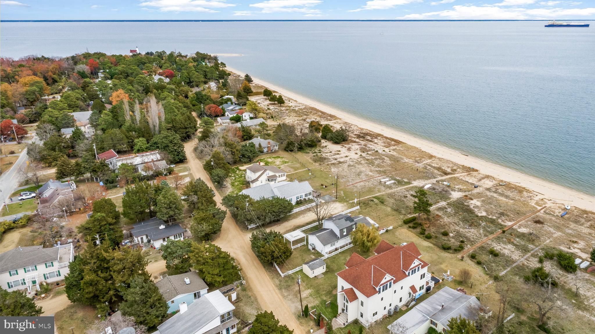 BAYFRONT BEAUTY!! Welcome to an extraordinary Chesapeake Bay estate where more than 5,000 square feet of refined coastal living meet private beach access and sweeping water views that shape every moment. This custom-built five-bedroom, five-bath home blends timeless craftsmanship with the serenity of the shoreline, offering a lifestyle that feels both luxurious and effortlessly relaxed.

A grand two-story foyer welcomes you with sunlight and soaring ceilings. To the right, a flexible guest suite or office offers privacy and comfort. To the left, a full bath is thoughtfully placed to serve the main level with ease.

Continue forward and the home opens into an impressive gourmet kitchen designed for gathering and everyday convenience. A massive center island boasts gorgeous granite countertops and is surrounded by custom weathered coastal cabinetry, professional-grade appliances, double wall ovens, a commercial-size refrigerator, and a custom vent hood. The bright eat-in area extends toward the Bay flowing into a large living room enhanced by sliding doors that invite you to step outside. A walk-in pantry adds practical storage and organization.

The main living room is warm and inviting, with wood floors, a gas fireplace, and an entire wall of windows framing uninterrupted water views. Whether relaxing by the fire or entertaining guests, this space celebrates the waterfront from every angle. Step outside onto a full-width deck where dining, lounging, and soaking in the coastal breeze become part of your daily rhythm.

Upstairs, on the second floor a spacious family room offers another dramatic vantage point, enhanced by magnificent 2 story wood cathedral ceilings and breathtaking views of the Chesapeake. Just beyond, the primary suite is a serene waterfront sanctuary with a private sitting area, its own upper deck, a generous walk-in closet with custom storage, and an ensuite bath with dual vanities and a beautifully tiled walk-in shower. Two additional bedrooms are located on this floor. One of which has an en-suite full bath.  A full bathroom located in the center hall serves the 3rd bedroom on this floor and the family room area.

Ascend to the 3rd level and discover a retreat perfect for both quiet moments and lively gatherings. The homes 5th bedroom is an suite of its own with a nicely updated full en-suite bathroom and decent sized walk-in closet. A cozy reading or office nook sits beneath warm wood ceilings. The large recreation room/potential 6th bedroom leads to a striking billiards area that opens to the family room below and allows for elevated views of the Bay, creating a one-of-a-kind leisure space. 

Outside, the property delivers the full waterfront lifestyle. A private boardwalk leads through natural grasses to your own sandy beach, where calm waves, long days on the water, and peaceful evenings by the shoreline become part of everyday living. Multiple decks provide both intimate and expansive outdoor spaces. For added convenience, the property includes a dedicated water hook-up and a 50-amp RV connection, ideal for RV owners or welcoming guests.

An additional separate lot is included with the property, increasing the total size to approximately .31 acres. While not buildable, this extra parcel offers exceptional value and flexibility—perfect for A FUTURE GARAGE, parking, storage, guest vehicles, or added outdoor space and privacy.

This home would make an excellent 2nd home with potential for substantial short-term rental income based on surrounding properties and seasonal demand.

This residence is a rare Chesapeake Bay offering—where elegant design, thoughtful functionality, and the magic of waterfront living come together seamlessly. Every detail invites you to relax, unwind, and embrace a lifestyle shaped by the beauty of the Bay.