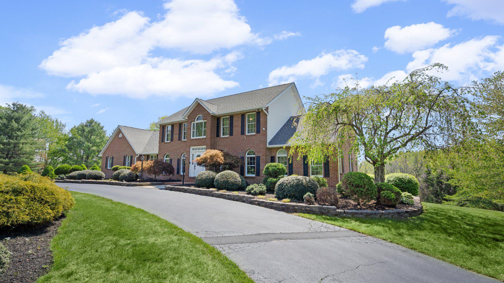 Welcome to this stunning brick and siding colonial set on over 2 acres of tree lined land in the highly sought after St. Anne community. From the moment you arrive, the circular driveway, expansive parking pad, and oversized 3 car side load garage set the tone for the exceptional features found throughout.

Step inside to a dramatic two story foyer showcasing recently refinished hardwood floors, flowing seamlessly into a private office accented by hardwood flooring and elegant Palladian windows. The formal dining room also features hardwood floors and Palladian windows, creating an ideal space for entertaining. The recently updated gourmet eat in kitchen is truly a showstopper, offering ceramic tile flooring, quartz countertops, glass tile backsplash, stainless steel appliances, recessed lighting, white 42 inch cabinetry with crown molding, a built in pantry, and a spacious eat in area with access to the garage and sliding glass doors leading to the rear deck.

The impressive two story family room features hardwood floors, recessed lighting, a striking brick hearth fireplace, and dual access to the screened portion of the rear deck. The main level primary suite provides a true retreat with cathedral ceilings, ceiling fan, recessed lighting, and a generous walk in closet. The recently updated primary bathroom includes a soaking tub and a separate ceramic surround shower with built in bench. A well appointed laundry room with built in cabinetry and countertops, along with an updated powder room, complete the main level.

Upstairs, a loft with hardwood floors and recessed lighting overlooks the family room below. The second bedroom offers carpet, a ceiling fan, and a private ensuite bath. Bedrooms three and four are both spacious with carpet and ceiling fans, and are serviced by an updated full hall bathroom. All bathrooms throughout the home have been recently updated.

The lower level is wide open, completely unfinished, and offers walkout access to the rear yard, providing endless possibilities for future expansion. Additional upgrades include zoned HVAC and an updated architectural shingle roof.

The exterior is truly exceptional, featuring a three tier deck with a screened in portion, stone retaining walls, and a partially fenced rear yard backing to trees, creating a private outdoor setting designed for both relaxation and entertaining.

Additional highlights include a heated garage and generator hookup, offering comfort and peace of mind year round.

Enjoy the perfect balance of privacy and convenience, tucked away from the crowds yet just a short drive to everyday amenities, dining, major commuter routes, goods & services. A rare opportunity offering space, setting, and thoughtful design throughout.