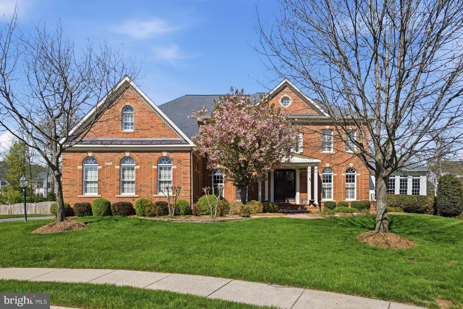 **ACCEPTING BACK UP OFFERS**
Welcome to this stunning and breathtaking Langley model, ideally situated in a cul-de-sac in the sought-after South Village section of South Riding, located in Loudoun County. This exceptional home is truly unmatched, offering extensive upgrades throughout both the interior and exterior.

From the moment you arrive, the custom brick walkway and double glass door entry set the tone for the elevated design found throughout. Inside, the home is filled with beautiful natural light and showcases hand-scraped flooring across the main and upper levels, along with thoughtfully curated finishes.

The expansive two-story family room is the heart of the home, featuring a coffered ceiling with recessed lighting, a wall of arched windows, and a central fireplace that anchors the space. The open layout provides seamless flow for both everyday living and entertaining.

The gourmet kitchen is designed for those who love to cook and gather, showcasing premium Monogram, Wolf, and Miele appliances, including a built-in espresso system. An oversized Carrera marble island offers additional seating and prep space, complemented by custom lighting, under-cabinet lighting, a walk-in pantry, and a butler’s pantry that can be used as a bar or coffee station.

Upstairs, you’ll find four oversized bedrooms, including a beautifully updated owner’s suite with a sitting area, a large walk-in closet, and a spa-inspired bath featuring an oversized shower, soaking tub, and private water closet. The owner’s suite also features a private deck, perfect for enjoying quiet mornings or unwinding in the evening.

One secondary bedroom offers its own private en-suite bath, while the remaining two bedrooms are connected by a well-appointed Jack and Jill bathroom. All secondary bedrooms offer generously sized closets.

The fully finished walk-up lower level is ideal for entertaining, featuring custom epoxy flooring, surround sound, a custom bar with upgraded lighting, a full bedroom and bath, and ample space for recreation or a private retreat.

Outdoor living is elevated like no other. The private, tree-lined backyard creates a breathtaking setting, featuring a custom pool and hot tub surrounded by imported travertine tile. A custom gazebo with stone fireplace and built-in bar enhances the experience, while multiple outdoor living areas include tri-level decking, a deck off the kitchen overlooking the pool, and a screened-in all-season deck with wood flooring. The yard is complete with custom landscaping and a partial wood and wrought iron fence.

Residents of South Riding enjoy an exceptional array of amenities, including multiple pools, tennis courts, playgrounds, playing fields, and miles of wooded and paved walking trails. Close by, you’ll also find a walking trail, a park with a soccer field, basketball court, and a tot lot with bench seating, perfect for enjoying time outdoors.

Additional features include a three-car garage with epoxy flooring, ample parking, a spacious mudroom with powder room access, plantation shutters, custom drapery, and designer lighting throughout. This home offers a rare combination of luxury, privacy, and exceptional indoor-outdoor living in one of Loudoun County’s premier communities. Photos may be virtually staged