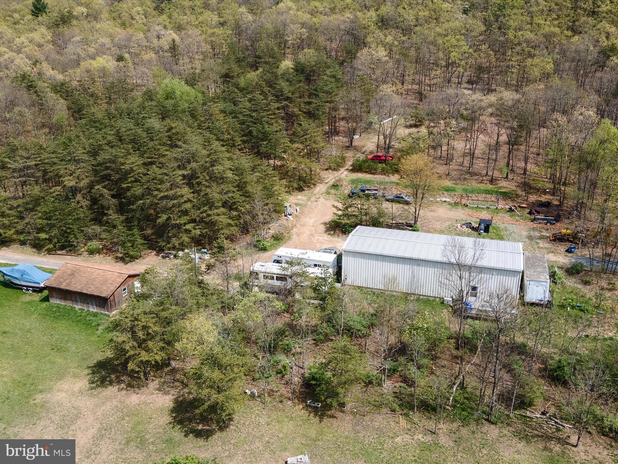 Man/woman cave, mechanic’s dream, mountain retreat — this one-of-a-kind property on 5 acres in Frederick County has it all! Located just 1 mile off Route 522 North, this private getaway offers the peace of backroads with the convenience of fully paved, state-maintained roads leading right to the driveway.

As you pull in, you’ll first spot the detached 3-bay garage — ideal for storing vehicles, equipment, or weekend toys. Continue up the drive and you’ll find dedicated RV parking with 50amp electric hookup, perfect for storing your RV. But the true showstopper? A 30x70 metal machine shop with soaring 19’ ceilings, a built-in truck lift, and plenty of space for all your mechanical projects, hobbies, or business needs.

Inside the shop is a fully equipped living space designed for comfort and function: a full kitchen, spacious bedroom with walk-in closet, tile shower, washer/dryer, and radiant heated floors on the main level. You’ll stay comfortable year-round with three mini-split HVAC units plus an outdoor wood boiler system that can heat both the shop and the living space, keeping it cozy even in the depths of winter.

Need storage? There’s more than enough between a 10x20 shed, a permanent tractor trailer, and a built-in gun safe tucked into the upstairs closet. And if you’re dreaming bigger, the land and 3-bedroom septic system were laid out with the future build of a full-sized home in mind.

Topped off with gorgeous mountain views and total versatility, this property is unlike anything else on the market.