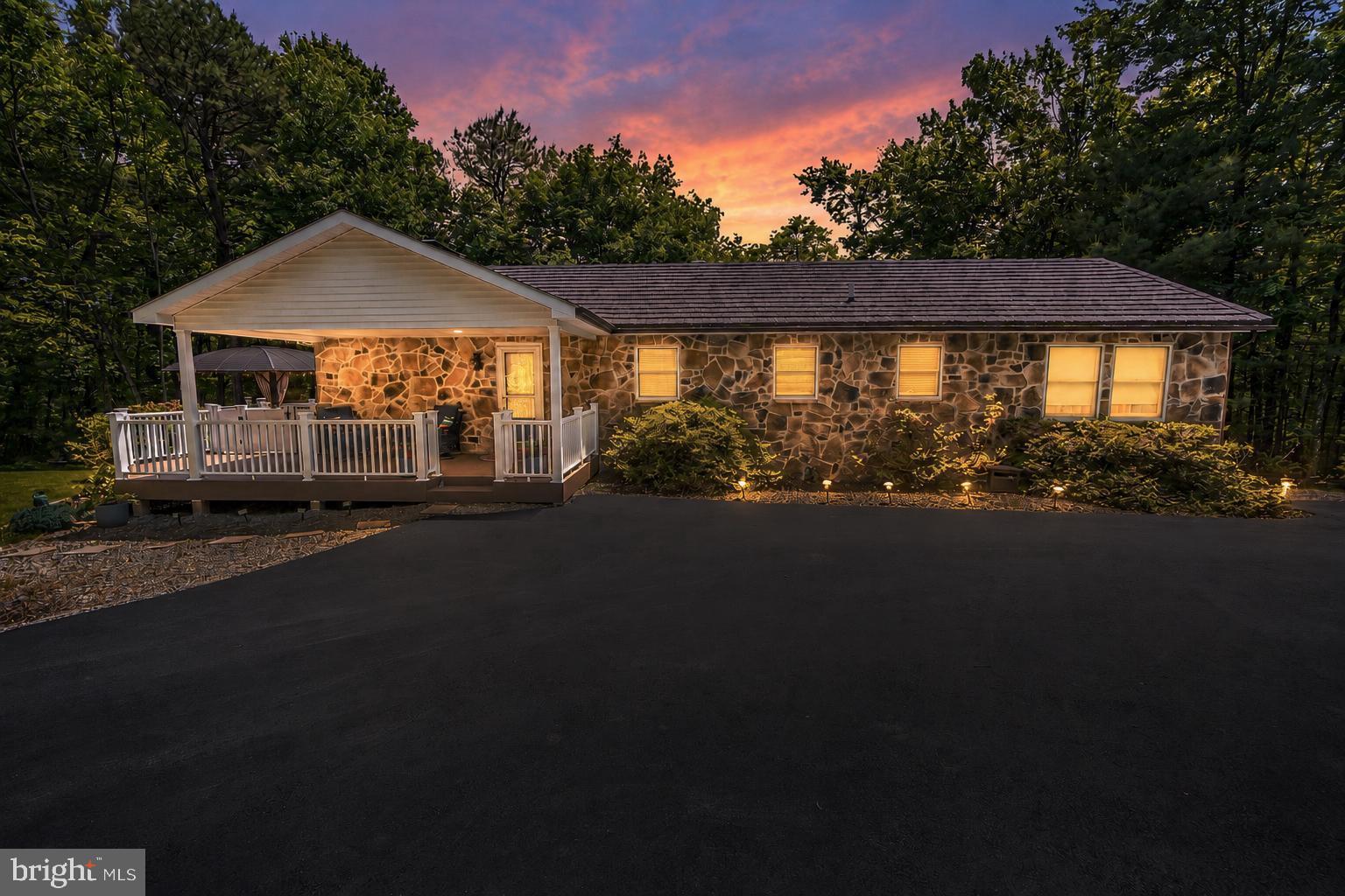 Meticulously maintained inside and out, this spacious 3 bedroom, 2 bath RANCH home offers a total of 2,808 finished square feet of comfortable living space in a peaceful Franklin Township setting close to Route 476 for easy commutes! Situated on a desirable CORNER lot with a wooded backdrop, this home delivers a rare combination of space, condition, setting, storage, and everyday functionality. The main level features a warm and inviting layout with a spacious kitchen offering abundant cabinetry, generous counter space, stainless steel appliances, and a convenient OPEN connection to the dining and living areas. The dining room provides plenty of space for gathering, while the living room offers a comfortable place to unwind with a propane fireplace and access to the bright sunroom. The sunroom is a true highlight of the home, featuring VAULTED ceilings, exposed beams, skylight, mini split, walls of windows, and beautiful views of the surrounding trees. The primary bedroom suite offers a private full bath and comfortable bedroom space, while two additional bedrooms and a second full bath complete the main level. The partially finished WALKOUT basement adds excellent additional living and recreational space, featuring a large family room with wood-burning stove, room for games, hobbies, storage, laundry, utilities, and access to two built-in garage bays. Outdoor living is another standout feature with an expansive WRAPAROUND deck, covered deck area, wooded views, and multiple areas to relax, grill, dine, or entertain. The property also offers exceptional parking and garage space with a paved driveway leading to a 2-car detached garage, plus a separate stone driveway leading to the rear of the home and two additional built-in garage bays, providing 4 total garage spaces. Additional highlights include Water Heater installed 3/2026, central AC, no HOA, a peaceful wooded setting, very close proximity to Beltzville Lake State Park, and convenient access to major commuter routes. A truly METICULOUSLY kept Franklin Township ranch with space, storage, setting, and standout indoor and outdoor living areas in a highly desirable location!