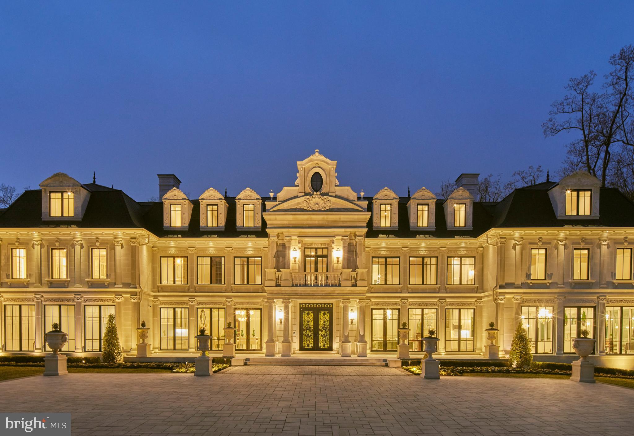 Set on nearly four acres along prestigious Georgetown Pike, this French-inspired estate offers 22,000 square feet of refined living across four levels with 10 ensuite bedrooms. A sweeping drive leads to wrought iron gates and a grand motor court, setting the stage for interiors designed with uncompromising craftsmanship. The marble foyer opens to expansive living and entertaining spaces, including a paneled library, elegant dining room, multiple kitchens, and a great room with panoramic garden views. The 3,300-square-foot primary suite features dual fireplaces, a private terrace, and an extraordinary two-story dressing closet.
Amenities extend to every level: a screening room, full spa with sauna and steam, massage and glam rooms, a fitness center, and a lounge with wet bar and direct garden access. Outdoors, resort-style grounds include a pool with waterfalls, a retractable 200-inch screen, and a covered al fresco dining pavilion with a built-in grilling kitchen. With smart-home technology, five garage bays, and secure parking for 30, this estate represents unmatched luxury just minutes from Washington, DC.