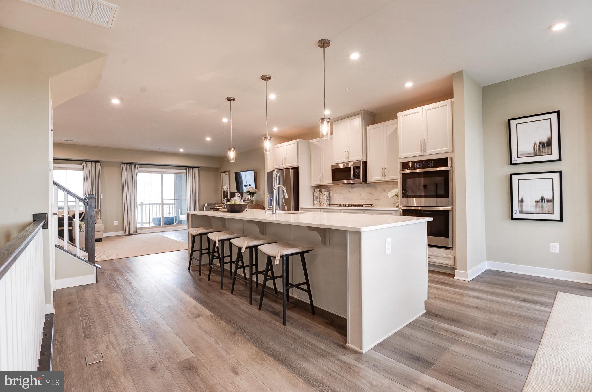 Previously, a BUILDER MODEL HOME at Arcola Town Center! Arcola Town Center is within a walking distance to Elaine E. Thompson Elementary School, Dulles Landing Town Center Shopping, & providing quick access to rte 50 & Loudoun County Parkway <br> <br> Condo is situated right across clubhouse & community swimming pool; just a block away to tot lot. Water, sewer, lawn mowing, & mulching is included <br> <br> Never lived in home! END CORNER, upper 2 levels (third & fourth), stacked, townhome style CONDO. Interior finished 2,484 sq ft equipped w/3 bedrms, 2 full baths, & 1 half bath; covered sky lanai & 1 rear car garage w/opener. Ample guest parking spaces available at the sub-division streets <br> <br> Ryan Homes built, Picasso floorplan, an open floorplan that allows light to flow through the entire area, an appealing modern design where comfort & convenience merge seamlessly; designed to be both practical & stylish. The first floor features chef's dream kitchen w/a huge work island & pantry, formal dining, & an amazing sky lanai off of the great room bringing the outdoors in. Upper bedrm level is a truly magnificent owner's suite featuring dual walk-in closets, sitting area, & a bath w/an oversized shower, dual vanities, & a water closet. Two generous secondary bedrms that share a hall bath w/dual bowl vanity, a linen closet, & a laundry complete the bedrm level <br> <br> Numerous options for groceries: Harris Teeter, Aldi, Walmart, Giant Foods, independent groceries, & more. Pharmacies: CVS & Walgreens. Easy access to shopping, transportation, recreation, & restaurants. Excellence in style, function & location