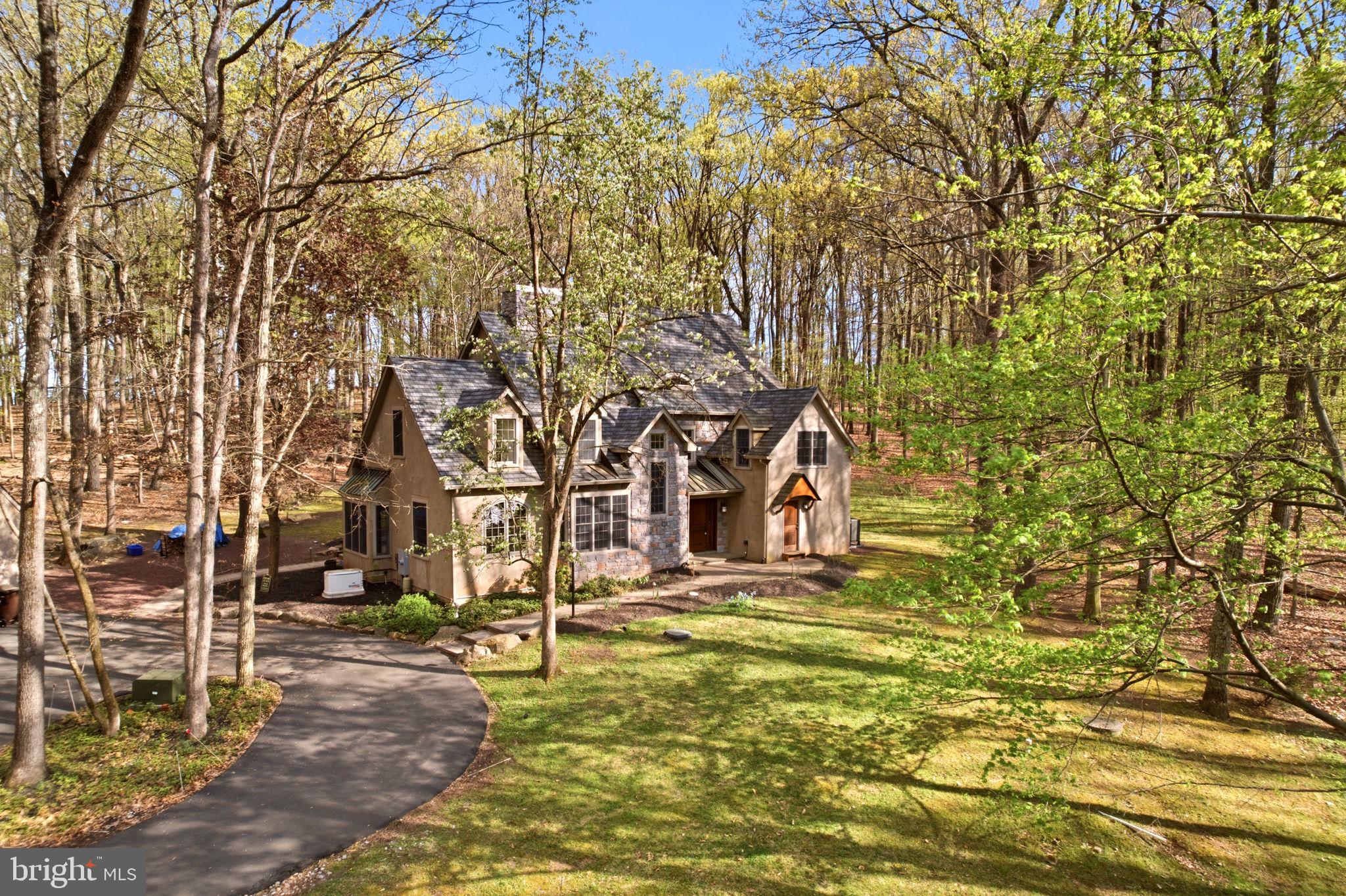 Enjoy a sense of arrival at this custom home perched in a lovely, wooded setting amongst the rolling hills of New Hope. Only a few minutes to the town center for dining, shopping and entertainment; the location offers a rare blend of convenience and total privacy. This home was completely redesigned and rebuilt in 2006, showcasing a more modern, open floor plan and taking advantage of the private nature views from every window. Featuring over 4,300 square feet of space, this 4 bedroom plus bonus loft,  three full and two half bath gem is versatile and spacious yet warm and inviting. Well-maintained and highlighting a New roof in 2022, Newer HVAC, New water heater and whole house generator simply move in and add your personal touches. Cozy up by the wood-burning fireplace in the family room, get the utmost in productivity from an inspiring home office with built-ins or create a homecooked meal in the expansive kitchen. The extensive paver patio and Sunroom are wonderful respites to enjoy the seasons all year long. Additional amenities include a 2 car detached garage with extra storage space, Andersen windows, Ralph Fey design, authentic wood floors, wonderful closet space throughout and New Hope - Solebury schools! Take a trip into New Hope Boro or Lambertville for a meal, coffee or stroll along the river.  Easy commuting access to the Route 202 corridor. Everything is at your fingertips yet once you pull into the driveway you are whisked away to a calmer, more peaceful surrounding.