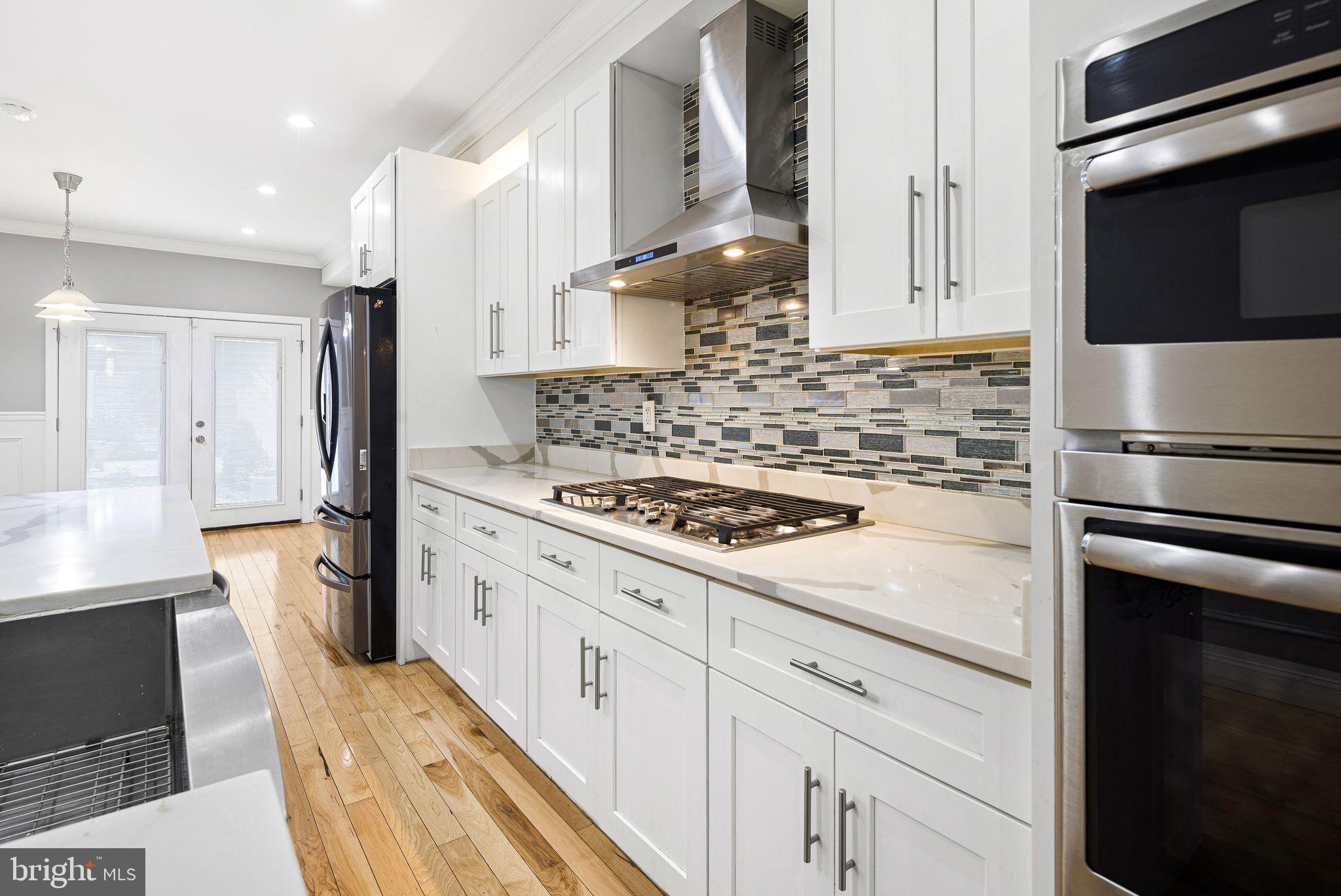 Must-see 3–4 bedroom, 3.5-bath home in charming Pennsport, where pride of ownership and community thrive! Fully renovated from top to bottom in 2018 and 3 years remaining on the tax abatement, this home features a beautifully landscaped 62' yard, finished basement, hardwood floors, and exquisite smart home and high-end finishes throughout. Bright, open, and thoughtfully designed, this home offers both space and style.
The main level welcomes you with a spacious living room boasting tall ceilings, crown molding, wainscoting, a large front window, coat closet, rich wood flooring, and a convenient half bath. The stunning kitchen features white cabinetry, granite countertops, tile backsplash, wine cooler, stainless steel appliances, a farmhouse sink, and an expansive island with pendant lighting, plus a large dining area leading out to the expansive, one-of-a-kind 62' landscaped backyard—complete with planters, stone, grass, river rock, granite, wood, slate, and even a pergola—creating a true urban oasis.
The second floor includes a front bedroom suite with two windows, a walk-through closet, and a private full bath with glass enclosed stall shower, tiled floors and walls and a modern vanity.  This level also features a versatile den or small bedroom, linen closet, full hall bath, and an additional rear bedroom with generous closet space and double windows. 
The entire third floor is dedicated to the primary suite, featuring two windows, hardwood flooring, a walk-in closet, and a luxurious all-tile four-piece bath with a whirlpool tub, glass-enclosed shower, stylish vanity, and Bluetooth-enabled features. From the hallway, step out to a rooftop terrace with lighting and electric, plus spiral stairs leading to a large rooftop deck (new in 2023) with sweeping sky views from sunrise to sunset.
The finished basement provides additional living space—perfect for a den, office, or family room—and includes laundry, mechanicals, and storage. 
Neighborhood attractions include Moyamensing Avenue, Dickinson Square Park, trendy hot spots and family restaurants, ease of access to the Delaware waterfront, convenient parking and public transportation. 3 years left of the tax abatement. Professional photos coming soon.