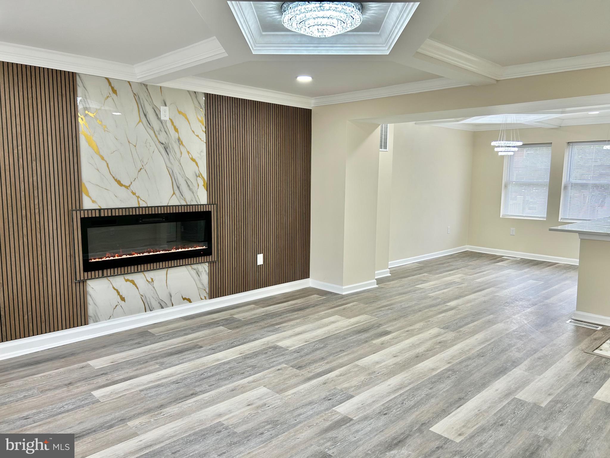 Welcome to this charmingly renovated Baltimore home, known as 3514 Elmora Avenue! You are sure to be blown away by the attention to detail paired with the modern elegance radiating from floor to ceiling. You are greeted with an airy open floor plan as you enter the living room, featuring stylishly designed coffered ceilings and an ambient fireplace insert nestled in the custom accent wall. The spacious living room flows seamlessly into the dining area perfect for entertaining or enjoying a meal. The bright dining area opens up to the show stopping gourmet kitchen, which offers an expansive quartz island, new stainless steel appliances, and sleek custom cabinetry. Off of the kitchen, you can access the new deck and fenced rear yard which is perfect for creating your own outdoor retreat! Upper level features three carpeted bedrooms with a luxe upgraded bathroom. The fully finished lower level includes a  cozy fourth bedroom in addition to a generous open area making the perfect space for a relaxing family room or rec room. Lower level also boasts a contemporary full bath, laundry, and access to the rear yard. Come experience the boundless charm and allure this home has to offer!