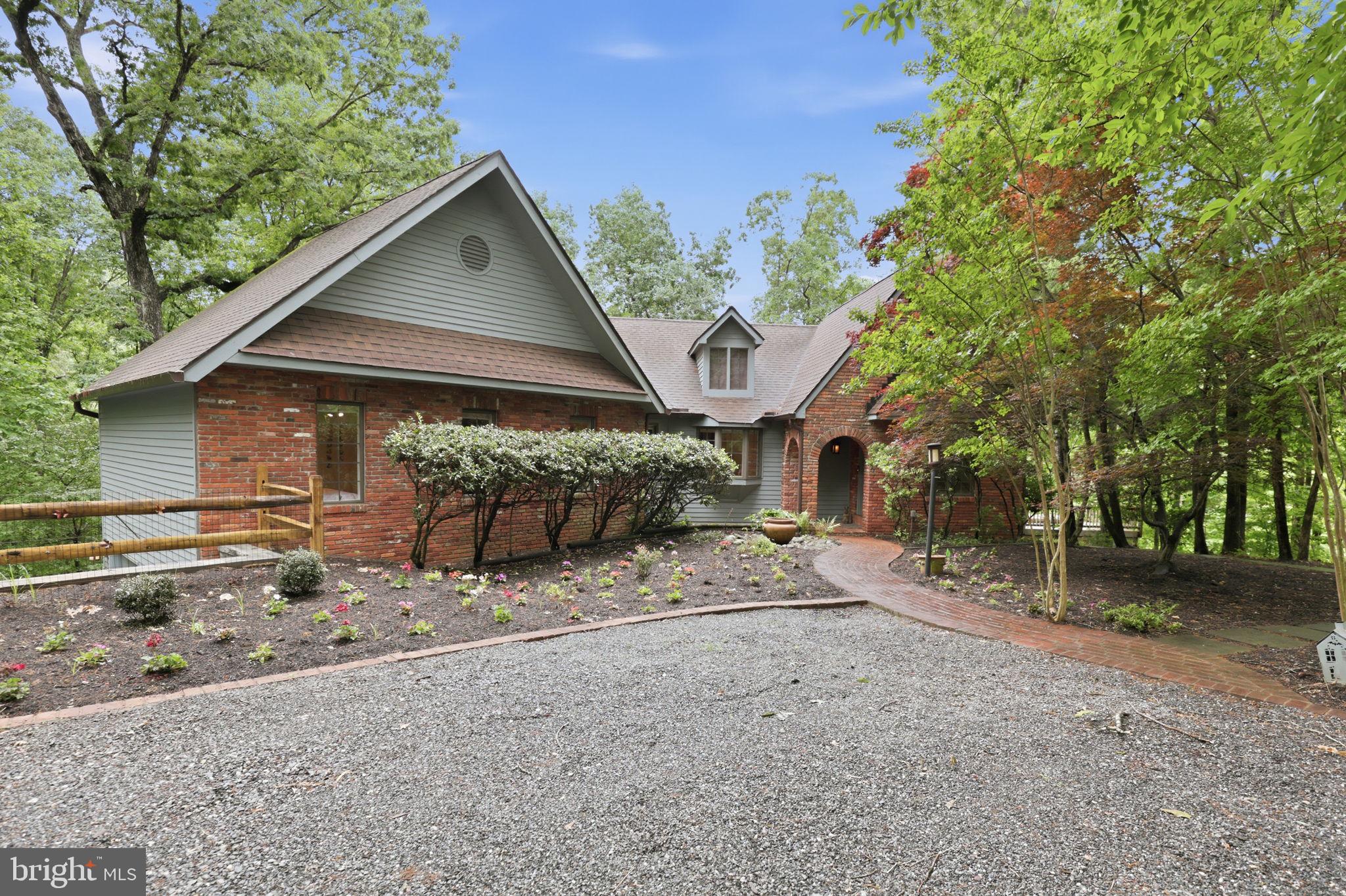 Welcome to this extraordinary French contemporary home tucked away on a beautifully wooded and incredibly private lot in sought-after Gingerville Woods, offering breathtaking water views and timeless architectural character throughout. 
With 4 bedrooms, 3.5 bathrooms, a dedicated office, and multiple indoor and outdoor living spaces, this one-of-a-kind home perfectly balances sophistication, warmth, and everyday comfort.
Designed to impress from the moment you walk in, the home showcases soaring wood-beamed cathedral ceilings, dramatic walls of windows, rich hardwood flooring, custom solid wood doors, and stunning French-inspired architectural details throughout. The spectacular great room is the heart of the home, anchored by a soaring stacked stone fireplace and filled with natural light while framing peaceful water and wooded views beyond.
The kitchen opens seamlessly into the dining and living spaces, creating an ideal layout for both entertaining and everyday living. French doors lead to an expansive multi-tiered deck overlooking the water, offering the perfect setting for morning coffee, outdoor dining, or relaxing evenings surrounded by nature.
The luxurious primary suite feels like a private retreat with exposed wood trusses, vaulted ceilings, gleaming hardwood floors, and a spa-inspired bath. Three additional bedrooms and a private office provide flexibility for guests, working from home, or multi-generational living.
Perfectly sited to maximize both privacy and views, this exceptional property offers the rare combination of dramatic contemporary interiors, timeless French country charm, and an incredible connection to the outdoors. Located in the desirable Gingerville Woods community with access to the community pool, tennis and sport courts, walking trails, and just minutes to Annapolis, shopping, restaurants, and commuter routes.