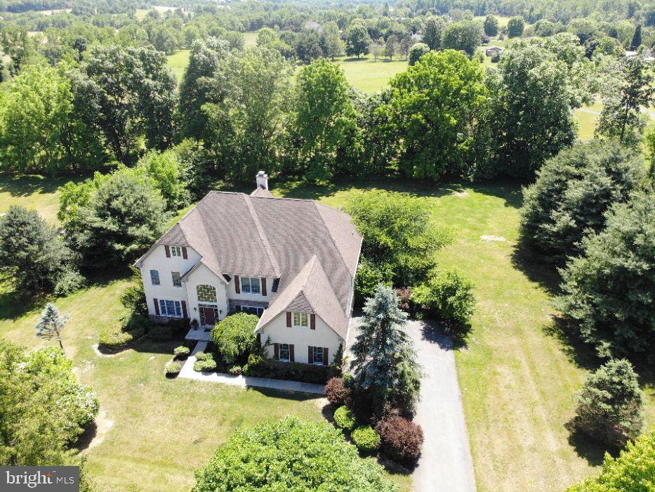 Welcome to Fox Creek Estates, one of Williams Township's most desirable communities. This stunning center hall colonial offers exceptional space, elegance, and versatility, set on beautifully landscaped grounds that provide a private and peaceful retreat. Step into the dramatic two-story foyer, where an open staircase and soaring ceiling create a remarkable first impression. The formal living and dining rooms are enhanced by custom moldings and timeless architectural details, while the spectacular two-story great room features a wood-burning fireplace and expansive windows that fill the home with natural light. The heart of the home is the massive gourmet kitchen, thoughtfully designed with granite countertops, a center island, desk area, walk-in pantry, and custom cream-colored cabinetry with oil-rubbed finishes. The main level also includes a charming sunroom with atrium door to the outdoor living space, a private den/office (could be a 1st- floor bedroom), convenient laundry/mudroom, and half bathroom. Upstairs, a balcony overlooks the great room below, adding to the home's open and airy feel. The luxurious primary suite is a true sanctuary, featuring a sitting/bonus room, two walk-in closets, and an exceptional spa-inspired bath with a two-sided glass shower, separate vanities, and dual toilet areas. Three additional generously sized bedrooms and two full baths complete the second floor. The fully finished lower level offers incredible flexibility for extended family living, guests, or entertaining. This space includes a granite kitchen, spacious living/recreation room with outside entrance, bedroom, modern full bath, walk-in closet, and an enormous storage area. Outside, enjoy your own backyard oasis featuring a beautiful stamped concrete patio, mature landscaping, and colorful flowering perennials that provide beauty and privacy throughout the seasons. Additional highlights include LP gas heat and hot water, central air conditioning, PEX plumbing, generator hookup capable of powering essential home systems, and a brand-new septic drainfield to be installed for added peace of mind. Ideally located with easy access to New Jersey, Riegelsville, downtown Easton, and Bethlehem, this remarkable property combines luxury, comfort, and convenience in an exceptional setting.  Showings begin on Sunday, 6/14 at 1 PM at the Open House!