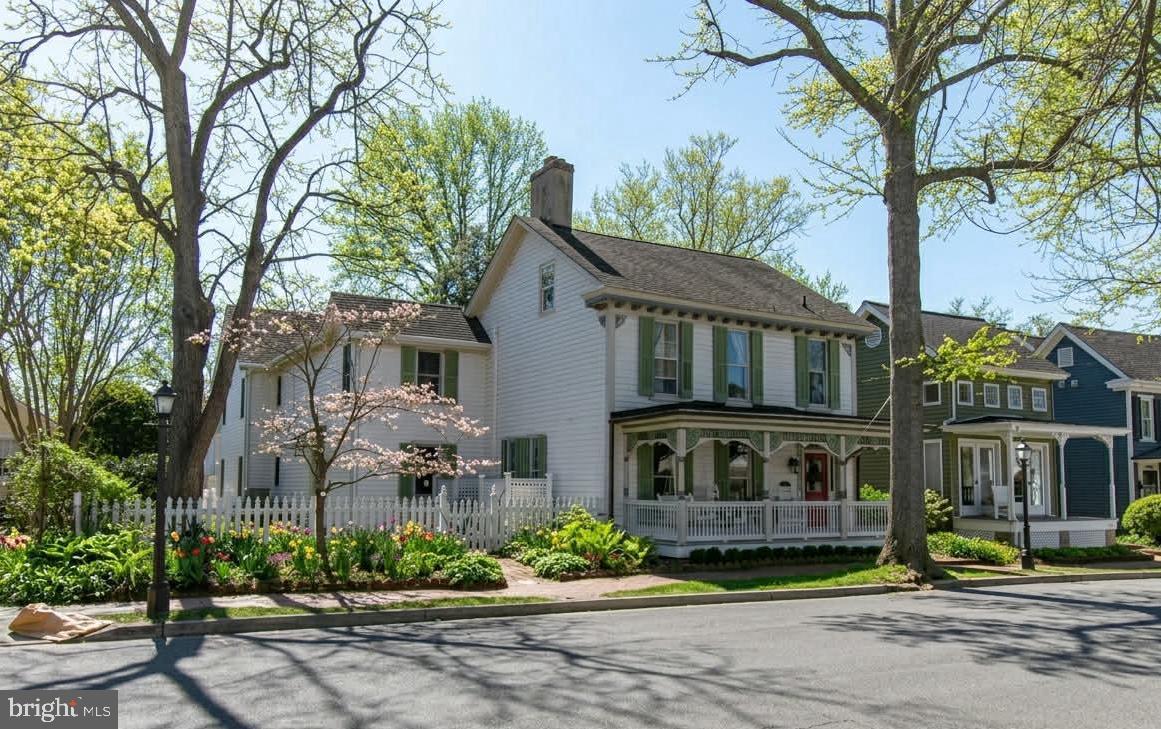 Enjoy historic in-town living in the heart of St. Michaels, where this beautifully maintained residence offers a rare combination of timeless architecture, a sought-after waterfront-adjacent location, and convenient access to the harbor, parks, trails, shops, and restaurants. Ideally located near the waterfront, scenic trails, park, kayak launch, and the town’s many amenities, the home provides easy access to the best of Eastern Shore living.

Inside, warm and inviting interiors feature hardwood floors throughout, multiple living areas, and four wood-burning fireplaces that enhance the home’s historic character. The flexible floor plan includes four bedrooms, four and one-half baths, a dedicated office, custom built-ins, and generous storage, well-suited for a variety of living arrangements and lifestyle needs.

Thoughtfully designed spaces offer both comfortable everyday living and additional room for guests, creative pursuits, work-from-home flexibility, or future customization.

Outdoor features include a landscaped fenced yard designed for privacy and low-maintenance enjoyment, along with a spacious patio ideal for outdoor entertaining and relaxation. A detached cottage provides added versatility for use as a studio, workshop, or storage space. Off-street parking is an added convenience within the Historic District.

Blending historic charm, adaptable living spaces, and an exceptional in-town location, this distinctive residence offers a unique opportunity to experience life in one of Maryland’s most desirable waterfront communities.