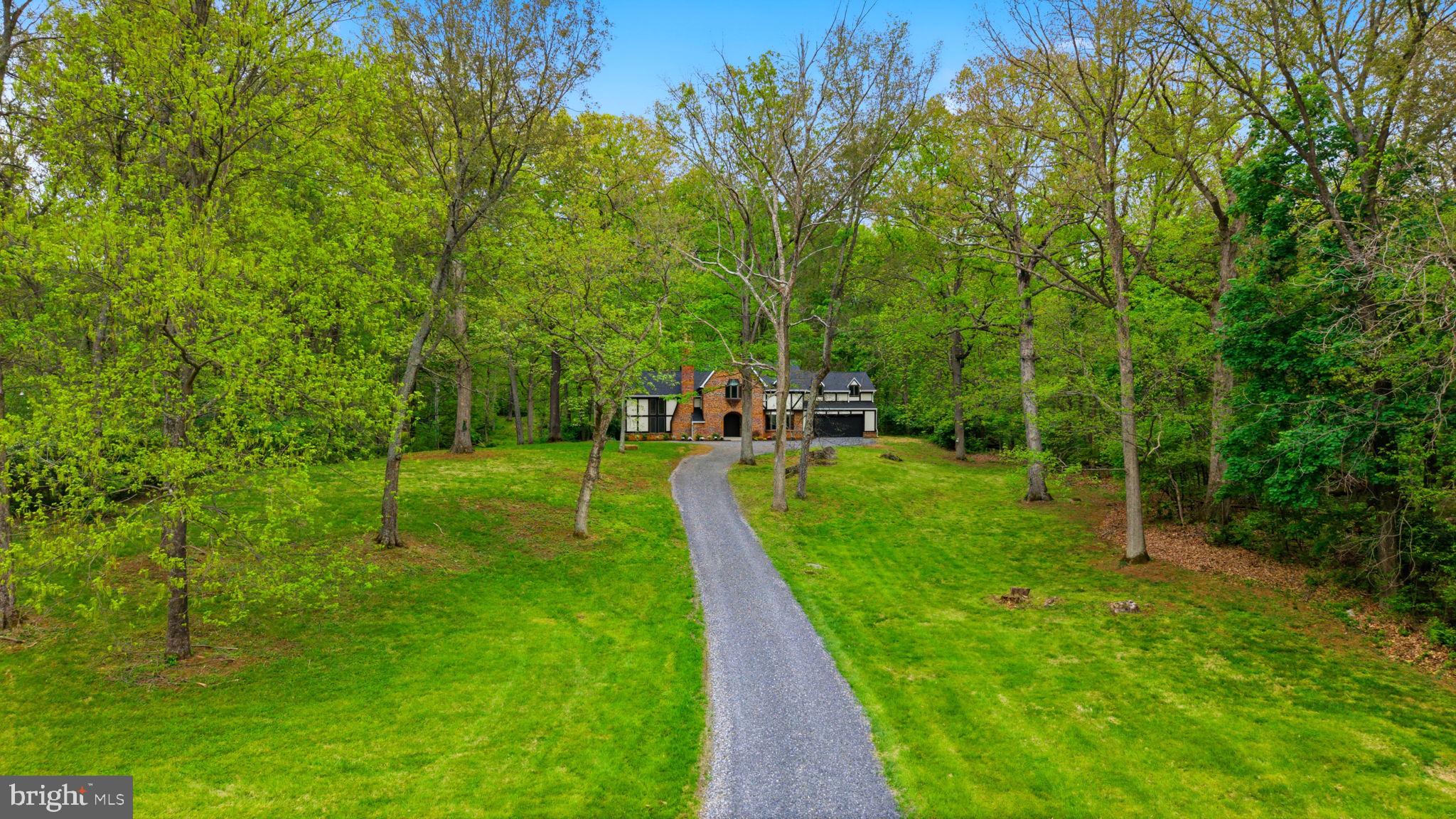 Discover this exquisite estate home nestled on 2.71 beautifully wooded acres, just north of Martinsburg—where privacy, comfort, and elegance come together in perfect harmony. Surrounded by mature trees and natural beauty, this property offers a peaceful retreat while still being conveniently located.

This stunning 4-bedroom home has been completely remodeled from top to bottom, showcasing high-end finishes and thoughtful design throughout. Step inside to find a gourmet kitchen that will impress any home chef, featuring quality cabinetry, sleek countertops, and ample space for cooking and entertaining. The formal dining room provides the perfect setting for gatherings and special occasions. The heart of the home is the soaring two-story family room, filled with natural light and anchored by a cozy fireplace—an ideal space to relax or entertain guests. The primary suite is a true sanctuary, offering a luxurious en-suite bath complete with a beautifully tiled shower with leaded glass accents and elegant granite vanities. The guest bath has been equally upgraded with matching granite finishes, ensuring style and comfort throughout.Step outside and enjoy your own private oasis. A newly built deck overlooks the serene backyard, while the stamped concrete patio below provides additional space for outdoor dining, entertaining, or simply soaking in the quiet surroundings.Additional features include a two-car garage and a stately, tree-lined driveway that creates a grand and welcoming entrance to the property.

If you're looking for a move-in ready home with modern upgrades, timeless charm, and unmatched tranquility, this exceptional property is a must-see.