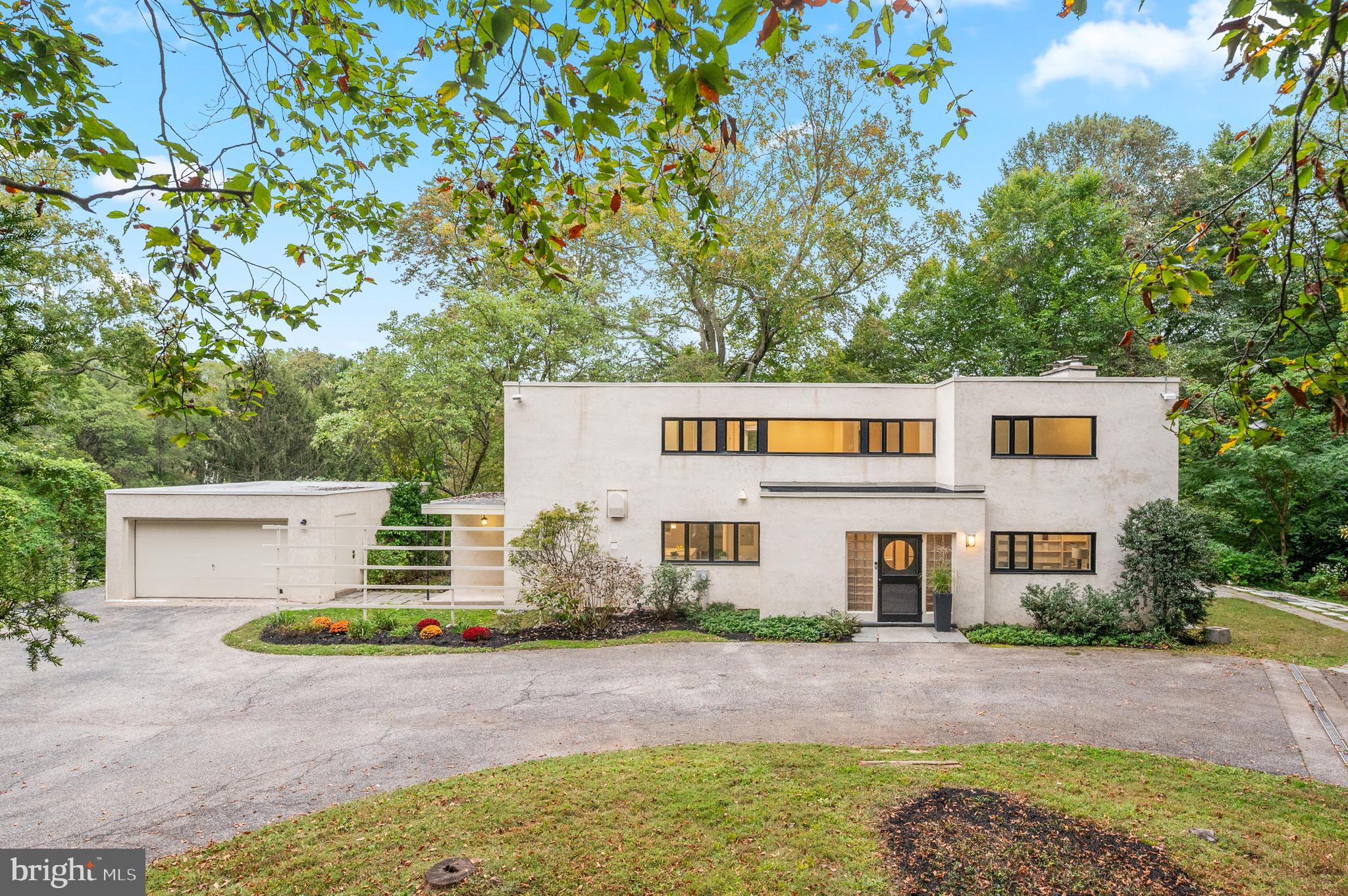 Tucked away at the end of a private cul-de-sac and set well back from Black Rock Road, this remarkable residence offers a rare combination of privacy, architectural pedigree, and natural beauty in the heart of Gladwyne. Situated on 2.6 acres within the award-winning Lower Merion School District, the home enjoys wooded views from every room and a serene connection to its surroundings. Originally designed in 1937 by architects Douglas Braik and Robert Montgomery Brown, it is a striking example of early International Style architecture, a precursor to the Mid-Century Modern movement. Defined by clean lines, flat rooflines, and expansive bands of windows, the stucco-on-masonry façade, geometric forms, and light-filled interiors embody timeless modern design decades ahead of its time.