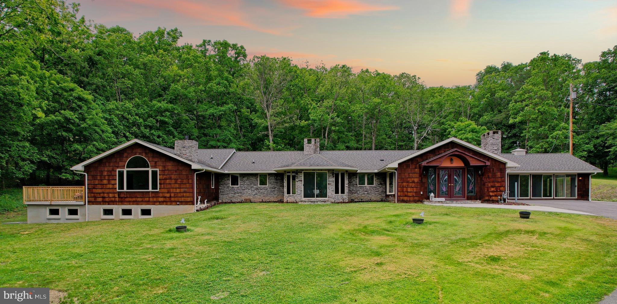 Luxury, Privacy, and Space—All in One Extraordinary LaVale Estate! Welcome to an exceptional remodeled residence where expansive one-level living, refined comfort, and 4.35 picturesque acres come together in a truly distinctive setting. This impressive L-shaped rancher offers four bedrooms, four full bathrooms, one half bathroom, three fireplaces, generous entertaining spaces, and remarkable flexibility for everyday living.  Surrounded by mature trees and open lawn, the property provides a peaceful retreat where you can relax on the spacious patio or deck, observe local wildlife, and enjoy the beauty of Western Maryland from the comfort of home. With ample acreage and additional usable land, the property may also offer future building or expansion possibilities, subject to applicable zoning, permits, and county approval.  The interior has been thoughtfully remodeled with new luxury vinyl plank flooring, updated lighting, fresh finishes, spacious bedroom suites, cedar-lined storage, multiple wet bars, radiant heated bathroom floors, and an extraordinary primary suite encompassing more than 950 square feet. Multiple fireplaces create warmth and character, while large windows and exterior doors bring the natural surroundings into view.  At the heart of the home is a kitchen measuring more than 400 square feet, complete with a large island, granite countertops, wine cooler, new refrigerator, updated molding, and provisions for accent lighting. Multiple dining and gathering areas make the home especially well suited for entertaining, extended-family living, or hosting overnight guests.  The property also includes a 25' x 35' three-bay garage, more than 1,100 square feet of basement space, a sauna, central air conditioning, central vacuum, an alarm system, new exterior lighting, a newly constructed retaining wall, and updated mechanical systems.  Outside, the 4.35-acre setting offers plenty of room for recreation, gardening, outdoor entertaining, or the addition of a pool. A separate 20' x 24' concrete pad toward the rear of the property could accommodate a basketball court, storage structure, workshop, or future studio, subject to approval.  Enjoy the privacy of a spacious country-like setting while remaining conveniently close to LaVale shopping and restaurants, UPMC Western Maryland, downtown Cumberland, Allegany College of Maryland, Interstate 68, Rocky Gap State Park and Casino, and the many outdoor recreation opportunities found throughout Western Maryland.  This is more than a home—it is a private retreat designed for comfort, entertaining, and an exceptional lifestyle.  Approx. Room Measurements: 
Living Room | 24' x 40',  Den and Dining Room | 33' x 15',  Study | Approximately 22' x 22'.  CALL TODAY TO SCHEUDLE A TOUR!