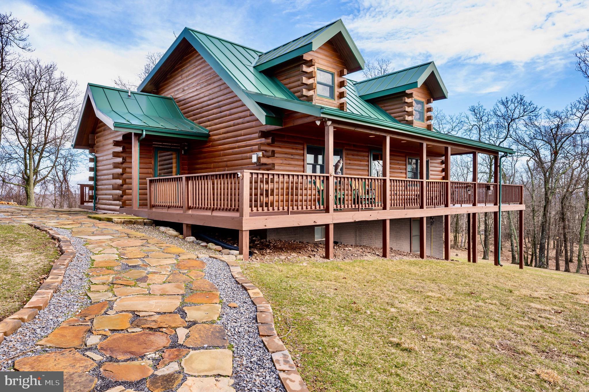 Welcome to your stunning Amish-built pine log cabin mountain retreat, where panoramic mountain views await from the wrap-around deck! Bask in the abundance of natural light that fills this meticulously maintained home. Set on 14 acres of picturesque landscape, this retreat features 4 bedrooms, 2.5 bathrooms, and a fully finished basement. With a 3-car garage, beautiful hickory hardwood floors and cabinets, high-speed fiber optic internet, and an in-home surge protection system, every detail has been crafted for your comfort and convenience. Experience the perfect blend of rustic charm and modern luxury in this idyllic getaway. Less than 20 minutes to Moorefield for shopping, dining/cafes. 25 minutes to Wardensville for organic farmers market, bookstores, and dining/cafes. 2 and 1/2 hours to D.C. Make an appointment today!
