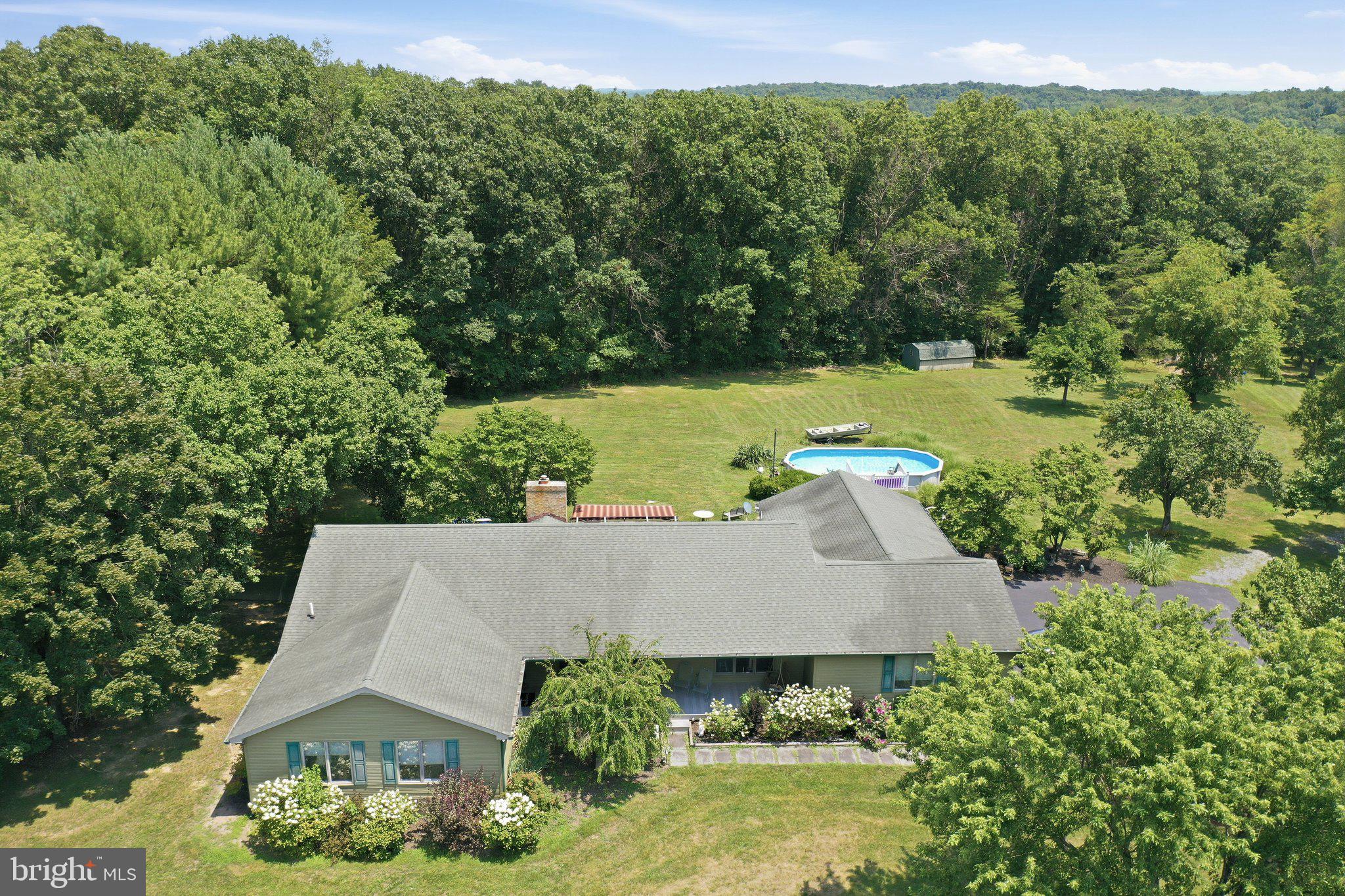 Discover the perfect blend of comfort and nature in this beautiful ranch-style home nestled in the serene Opequon Ridge III community. Spanning 2,670 sq. ft. , this residence boasts an open floor plan, and easy one-level living, creating an inviting space for gatherings or quiets times at home. Enjoy cozy evenings by one of the two gas fireplaces, or relax on the porch on those warm summer evenings. The kitchen open to the family room and is equipped with stainless steel appliances, including a built-in microwave and dishwasher, ensuring culinary adventures are a delight. With three bedrooms and two and a half baths, this home offers ample space for relaxation and privacy. Step outside to your own personal oasis over 9 acres of beautifully landscaped grounds and natural wooded areas, providing a tranquil backdrop and a sense of seclusion. Enjoy the outdoors on the private deck, patio, or enclosed porch, perfect for entertaining or simply soaking in the lovely park-like setting. Take a stroll through the woods to your own hidden observation deck in the trees to watch the abundant wildlife or explore Opequon Creek at the back of the property.  An above-ground pool invites you to cool off on warm summer days or relax in the hot tub. Three sheds offer tons additional storage for yard toys or gardening tools. Home offers a whole house generator so power outages aren't a concern, a whole house water treatment system and ring camera system. This home is not just a residence; it's a lifestyle waiting to be embraced. Don't miss your chance to make this enchanting property your own! Seller has found there home of choice. Professional Photos Coming Soon!
