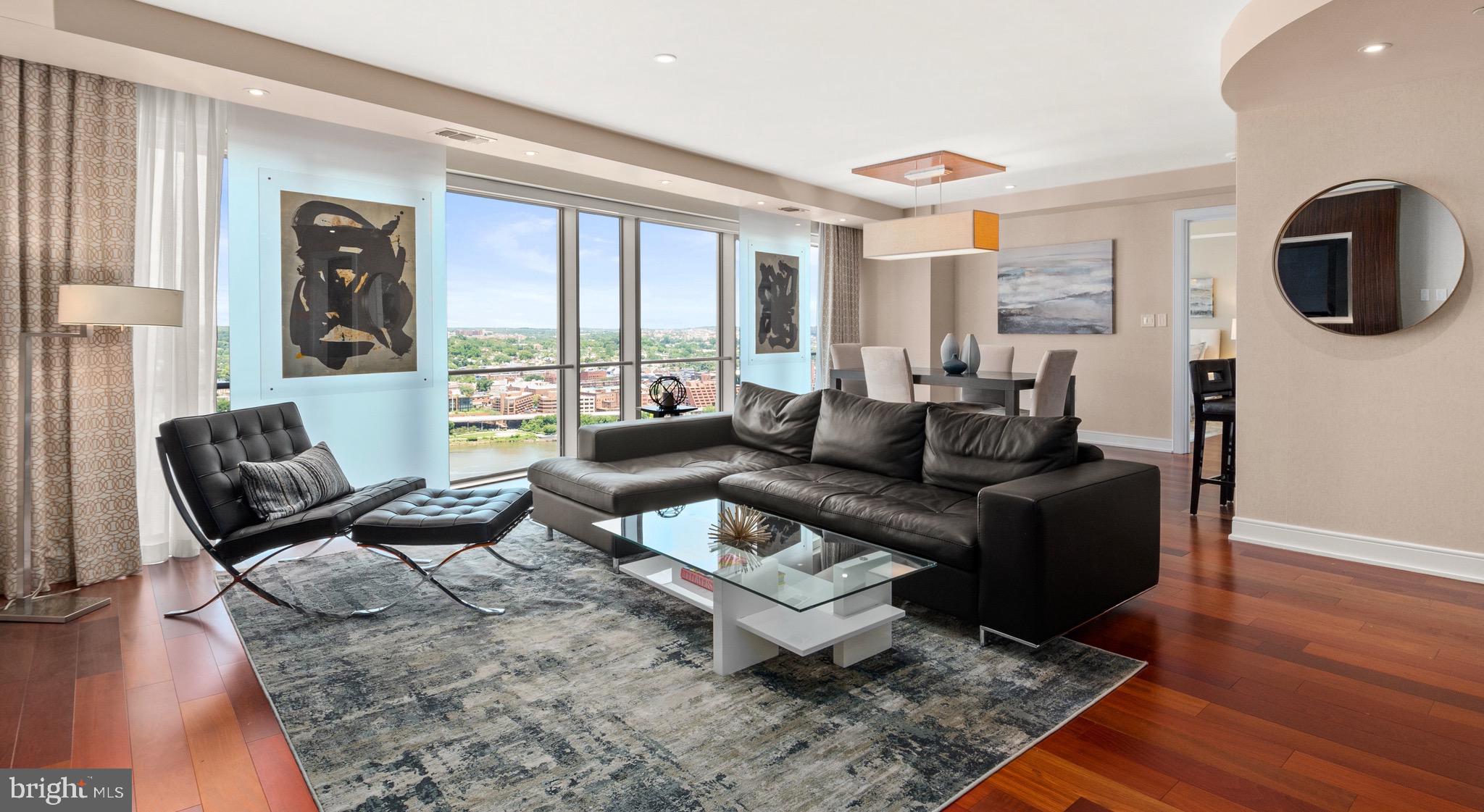 Welcome to the Waterview Condominium! This is one of area’s most luxurious buildings, located in the heart of Rosslyn, one of Arlington, Virginia’s most sought-after neighborhoods! This stunning three-bedroom, three-and-a-half bathroom penthouse offers the most spectacular views! This rare find features 2,260 square feet of elegantly finished space on one level overlooking the Potomac River and DC.

As you enter this fabulous penthouse, the foyer features a tray ceiling showcasing mother of pearl marble and is beautifully wrapped with decorator fabric wallpaper. The entire unit features Brazilian Cherry hardwood floors, crown molding, and floor to ceiling windows with automatic electronic shades highlighting breathtaking views of Georgetown and the Potomac River! The foyer includes a powder room complete with designer wood vanity and grasscloth wallpaper. A smart closet and hall closet provide additional storage. The open living area showcases a shellac burl wood television surround and sliding art panels and flows perfectly into the dining area. The gourmet kitchen is complete with granite countertops, custom cabinetry, and stainless steel appliances. The Viking warming drawer, Miele dishwasher and Sub-Zero wine refrigerator highlight the luxury of this condominium! The gas range cooktop and custom tile backsplash are the finishing touches on this modern kitchen. The laundry room includes a Bosch front-loading washer and dryer with built-in shelving for storage. The spacious primary bedroom is perfectly wrapped with floor-to-ceiling windows featuring exquisite views and an oversized walk-in closet with custom shelves and designer wallpaper. The primary bathroom highlights similar views and features a double vanity with marble countertops and a custom tile, walk-in shower. The second bedroom is gracious in size, complete with curtain panels and a walk-in closet. The en-suite bathroom features a wood vanity, marble floors and countertop, and an extra-deep, full-size bathtub and shower. The third bedroom can also be utilized as a den or office and includes a walk-in closet and en-suite bathroom complete with a marble-tiled walk-in shower and wood vanity.

Not only is the Waterview Condominium in a prime location, it also features amenities such as the 24/7 concierge service, fitness center, attached parking garage, and rooftop access! With three assigned parking spaces and an additional storage unit, accessibility and additional space will never be an issue! The open-air rooftop deck includes fire tables, Weber grills, and ample seating, allowing you to sit back and enjoy the stunning panoramic views of DC! Located steps from the Rosslyn Metro Station, less than a mile away from Georgetown and ten minutes away from Reagan National Airport, you will enjoy the convenience of being in a truly central location. With all this condominium has to offer, it surely will not last. Do not miss this special opportunity!