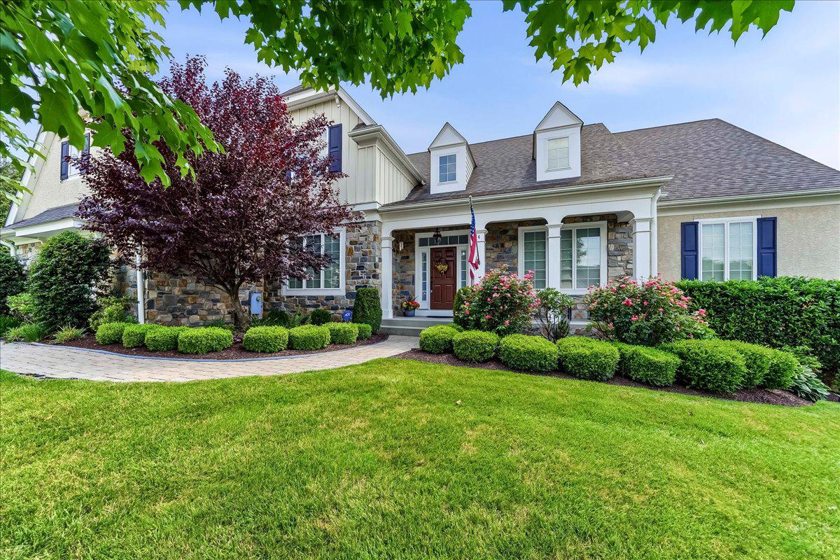 Nestled in the prestigious Andover subdivision, this exquisite traditional home offers a harmonious blend of luxury and comfort. The residence boasts 4 spacious bedrooms and 3 elegantly appointed bathrooms (and 2 additional powder rooms), providing ample space for relaxation and entertainment. Curved paver walkway leads to a deep front porch, perfect for your morning coffee or evening beverage.  Step inside to discover a thoughtfully designed interior featuring expansive site-finished oak floors, crown moldings, substantial trimwork, and an open floor plan that invites natural light. You'll be greeted by the stately center hall staircase and open feel.  To the left is the formal dining room with adjacent butlers pantry.  The butlers pantry is complete with wet bar and wine refrigerator.  To the right is the living room (which could double as an office or other room of your choosing).  The gourmet kitchen, complete with a large island, granite counters, stainless steel appliances (including a double over) and adjacent morning room, seamlessly flows into the family room, perfect for gatherings. Enjoy cozy evenings by the gas fireplace enjoying private views of the rear yard through expansive transom windows.   Adding further interest and character, the gas fireplace is flanked by custom built-in shelving complete with surround sound speaker system.  And the FIRST FLOOR primary suite is a true retreat, featuring a tray ceiling, walk-in closet, and a lavish en-suite bathroom.  Tiled bathroom offers an oversized walk-in shower, double vanity and plenty of space.  Additional highlights include a main floor laundry room/pantry, recessed lighting, and a efficient 1st floor office which could equally be your generously sized pantry.  Upstairs you are welcomed by an open landing leading to a reading nook/office area/flex space and 3 additional bedrooms.  Two of the bedrooms are served by a double vanity Jack & Jill bathroom, the other with an included en-suite.  The downstairs finished lower level is a daylight, walk-out haven with a completely flexible floorplan.  Lower level includes expansive tile floor, recessed lights, large wet bar (with included refrigerator), powder room, and plenty of storage.  Outside, the property sits on a premium 0.34-acre lot and backing onto a serene common area, ensuring privacy and tranquility. The outdoor living space is enhanced by a spacious deck and patio, ideal for summer barbecues or quiet evenings under the stars. The side-entry 3-car garage and ample driveway parking add to the convenience. Located in West Chester Area School District, this home offers easy access to local amenities and scenic surroundings. Experience the perfect blend of luxury living and a warm, inviting atmosphere in this remarkable property.