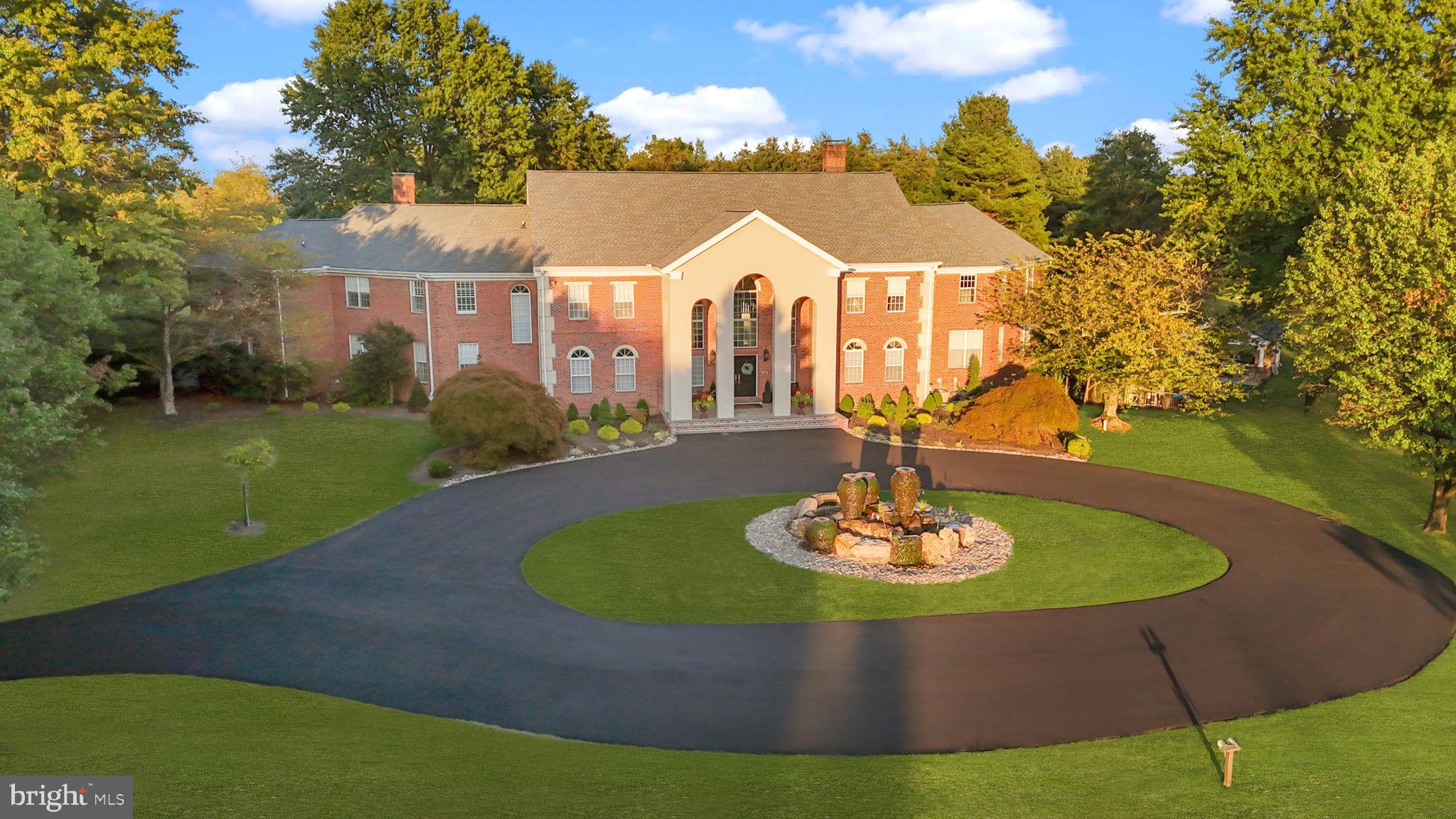 The Reimagined Twin Oaks: An Upper Makefield Sanctuary! Welcome to Twin Oaks, a commanding Georgian-style solid brick manor that seamlessly balances architectural grandeur with the comfort of a true family haven. Set at the end of an exclusive enclave of just nine estates spanning 90 acres, this 10-acre property has been significantly elevated through a comprehensive renovation. ($2M+ in Upgrades)!!  Arrival is marked by stately brick pillars with integrated lanterns, opening to a long, private tree-lined drive accented by classic lamp posts. The approach culminates in a circular driveway and a dramatic cantilevered front portico, centered by a breathtaking 20-foot custom fountain by Philadelphia Waterscapes. With bubbling spheres and cascading urns flowing into a self-replenishing pebble basin, this artisanal feature creates a serene, Zen-like introduction to the home.  Outdoor Living & Resort Amenities: The rear grounds have been transformed into a private resort designed for both grand entertaining and everyday relaxation. A massive swimming pool anchors the space, surrounded by an expansive stamped concrete patio and lush professional landscaping. A spectacular pavilion features a custom bar with seating and a stone fireplace for year-round enjoyment. A sprawling Trex deck offers a maintenance-free transition to the manicured grounds and the professionally resurfaced private tennis court. A dedicated dog fence encloses part of the yard with dual access to the four car side-entry garage and deck, providing both security and freedom. The Grand Foyer & Culinary Suites: Inside, a dramatic two-story foyer with boxed wall trim is flanked by twin butterfly staircases, drawing the eye toward the two-story great room beyond. The chef’s kitchen has been fully reimagined by luxury builders Worthington & Shagen and features a professional Viking range, Sub-Zero refrigeration with wine storage, and a built-in Miele coffee system. Designed for effortless hosting, a separate walk-in pantry room with custom cabinetry and shelving houses secondary appliances and entertaining essentials. This wing flows into a renovated mudroom and laundry suite, complete with a 38-inch stainless steel dog-grooming tub. Living Quarters & Wellness Wing: The layout offers a balance of scale and intimacy. The primary suite is a private sanctuary with a fully renovated bath featuring a custom steam shower, radiant heated floors, heated towel rack, TOTO toilet, and a couture-level dressing room created from a former bedroom. In addition to four other bedrooms, two expansive multi-room suites—each with 3 bedrooms—provide ideal accommodations for guests or multi-generational living. Eight additional en-suite baths have been expertly updated. The second level is completed by a spa room with a Zen ambiance, offering a sauna and two extra-deep luxury whirlpool tubs with inline heaters that can also function as cold plunges. The Club Level & Smart Integration: The walk-out lower level functions as a private social club with full Lutron smart-lighting integration. Highlights include an eight-person speakeasy bar, a state-of-the-art cinema with eight luxury recline leather seats, and an athletic wing featuring a basketball area with professional maple flooring and a glass-enclosed home gym. Two oversized storage rooms & a pool house section with a full bathroom complete this 2800sqft+ level. Turnkey Quality & Special Features: Mechanically superior, the home includes a new roof and updated high-efficiency systems. A fully integrated smart-home platform allows lighting, HVAC, theater features, pool systems, speakers, waterfalls, and lighting to be controlled via mobile device. Located within the Blue Ribbon–rated Council Rock North School District and minutes from Newtown, Princeton, and trains to NYC. With its scale, setting, and turnkey condition--at a fraction of the cost and time required to build new  --Twin Oaks is a legacy estate built for generations!