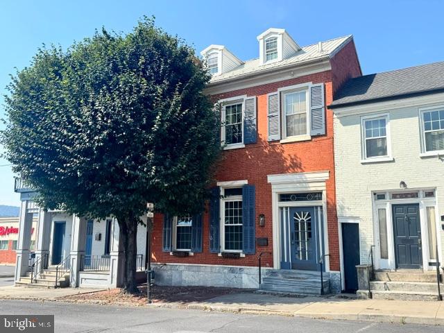 Classic brick residence with separate commercial office space on 1st floor. Over 3,000 sf of finished space with economical natural gas, hot-water baseboard heat. Multiple built-in air conditioning units and a mini-split provide some cooling. The office consists of a large waiting room/reception desk, 3 exam rooms/offices, a private office, powder room and records storage.  The living quarters contains a rec room and full, tile bath in the basement, a bedroom, full bath and open concept kitchen/dining/living room on the 2nd floor, and  a cozy bunk room with built-ins in the semi-finished attic.  There is a delightful screened porch off the dining area. Outside is a private courtyard sitting between the dwelling and the 2 car brick garage (accessed from alley).  Whether you are looking to move your business, live in a walkable location, or both, you need to check out this unique property that is believed to have been built in the late 1800's. Original/vintage items include the stone curb, granite foundation face and outside stairs, wooden louvered shutters, brick sidewalk and some random width wood flooring.