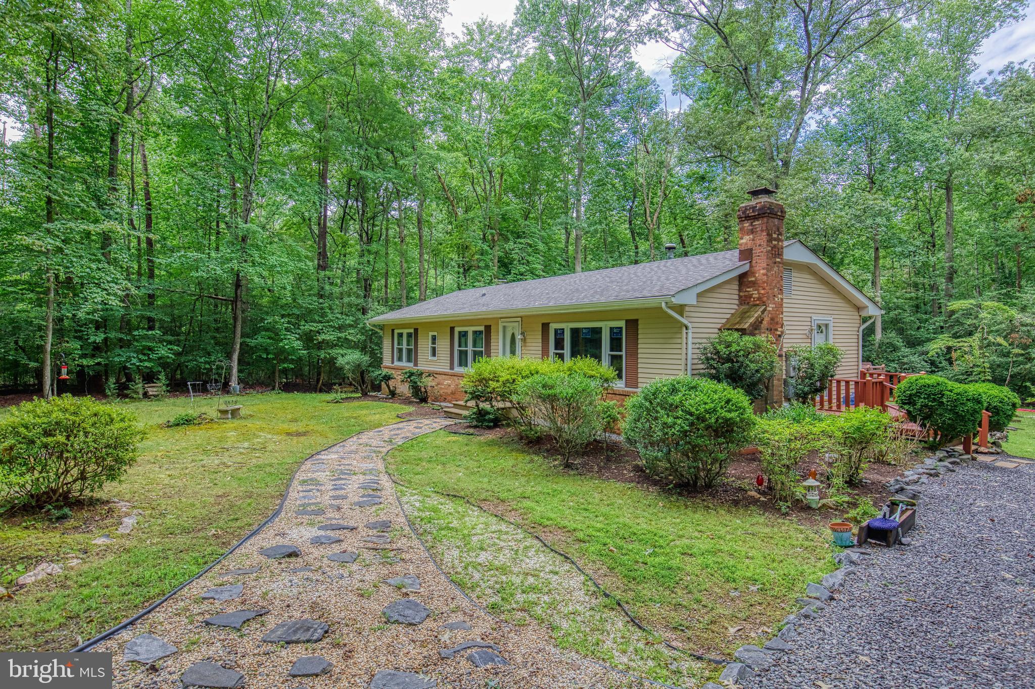 Discover the tranquility of 11616 Forest Walk Drive, nestled in the serene neighborhood of Forest Walk. This charming one-story home spans 5.8 acres and features three bedrooms, 1.5 bathrooms, and elegant parquet flooring throughout. Embrace outdoor living with four campsites, inviting walking trails, a quaint chicken coop, and more!  Outside, enjoy an under-roof target range, an upgraded main bathroom, and a spacious 16-by-30 deck perfect for gatherings. Recently updated appliances and windows from 2024 ensure modern comfort and efficiency.  Located within the esteemed Riverbend High School district, this property blends tranquility with historical allure, surrounded by battlegrounds and National Park territory. Relax on the rear deck as distant bugle calls play "taps."  Inside, entertain in the formal living room with a cozy fireplace, dine in the separate dining room, and prepare meals in the generously sized galley-style kitchen equipped with new appliances. Laundry facilities enhance convenience.  Whether you're bringing chickens to their new coop or seeking peaceful seclusion, this property, with optional HOA and A-2 zoning, offers a lifestyle immersed in natural beauty and rich history. Don't miss your chance to own this unique retreat!