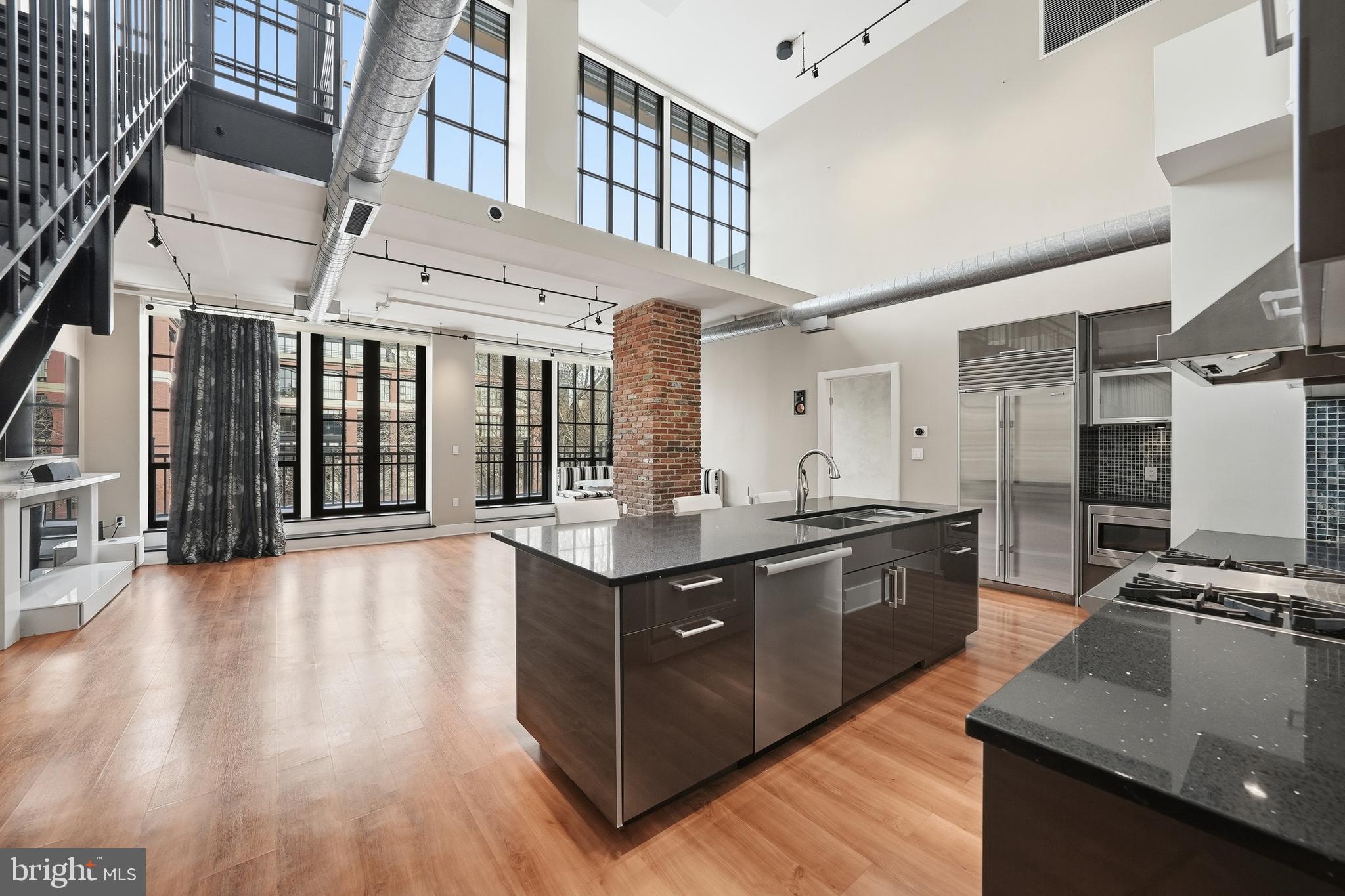 This Mercer ​penthouse delivers true contemporary sophistication in the heart of Rosslyn. Soaring two-story ceilings and walls of floor-to-ceiling glass flood the space with natural light, creating a dramatic New York–inspired loft aesthetic rarely found in the area. The open-concept design is anchored by a stunning gourmet kitchen outfitted with top-tier appliances and every amenity a serious chef would desire. A convenient pantry, expansive living and dining areas, and seamless access to a full-length terrace that connects the principal rooms make this home ideal for both entertaining and everyday living.

Two spacious primary suites provide comfort and privacy, while the generous den is perfect for a home office or guest space. Upstairs, a second-story veranda offers an additional private outdoor retreat, complete with an automated awning.  

More than $300,000 has been invested to elevate this residence, including a comprehensive Control4 smart home system managing security, audio, video, lighting, three integrated plasma TVs, automated blinds, and awning, all delivering effortless, high-end living at every turn.

Enjoy two dedicated garage parking spaces and access to exceptional building amenities, including a sunlit fitness center, outdoor pool, sleek party room, and a staffed front desk. Ideally located just steps from Metro, restaurants, and shopping, this rarely available two-story loft places you in the center of it all.