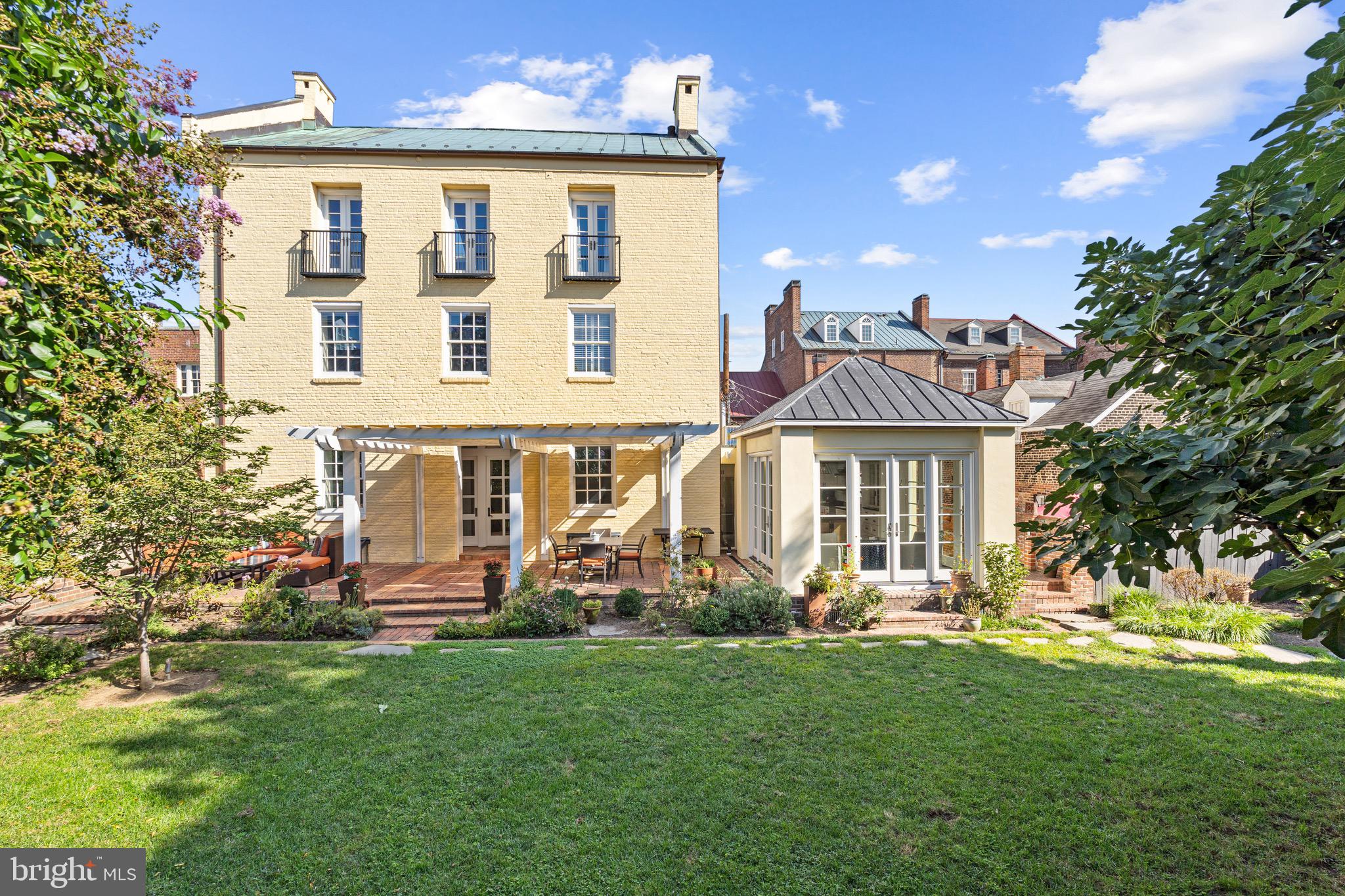Welcome to 2 Swifts Alley, an exquisite piece of Alexandria's history beautifully melded with modern luxury. This distinguished 4-bedroom, 4.5-bathroom home offers a unique blend of character, history, privacy, and contemporary comforts, making it a true gem in the heart of Old Town. This remarkable property, circa 1780, was once a tobacco warehouse, and its rich heritage is evident in the original wood beams that grace the home's interior. The historic character is seamlessly combined with modern amenities to provide a comfortable and elegant living experience. With over 5,300 square feet of finished living space, this home offers ample room for both relaxation and entertainment. Hardwood floors, recessed lighting and multiple fireplaces enhance the ambiance, while the oversized windows and 12-foot-high ceilings infuse each room with natural light. The renovated kitchen (2019) is a culinary enthusiast's dream, while the renovated primary bath (2019) and guest bathroom provide a touch of contemporary luxury. A reconfigured third level is perfect for guests or families (imagine a separate floor just for the kids or guests!) with two additional bedrooms, renovated bath, and large upper-level family room. The breakfast room, with its expansive windows, offers a delightful space to start your day with a view of the gardens. The lower level unveils versatile spaces including a  recreation room with grand fireplace and stone floors, a dedicated gym area, and lower-level pantry that can be reimagined into your dream wine cellar. Nestled on a 5,750 square foot lot, this property presents a large yard perfect for outdoor gatherings and recreational activities. Imagine hosting summer barbecues, playing fetch with the family dog or enjoying a leisurely game of croquet in this serene space. Convenience is key, with just one block separating you from the charming shops and restaurants of Old Town Alexandria, City Hall, and the Saturday Farmer's Market. Commuting is a breeze with easy access to major routes, public transport - being less than a mile away from the King Street Metro and Amtrak station. National Harbor, Amazon's HQ2, Washington DC, and more are all within a short drive. A valuable bonus in Old Town, this property offers one parking spot for your convenience. Don't miss your opportunity to own a piece of Alexandria's history while enjoying all the modern comforts this home has to offer.
