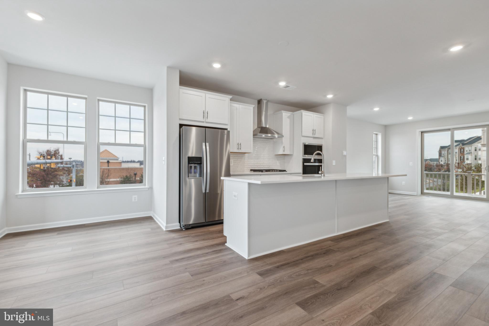 End unit new construction 4-bedroom townhome located in the prime Leesburg location! From the moment you step through the front door, you'll be greeted by an open foyer with a bedroom & full bath, perfect for a home office or guest suite. Oak staircase leading you to the main level. The kitchen boasts high end modern finishes with shaker-style white cabinetry, quartz counters, and gourmet kitchen appliances with sleek hood vent. The oversized island, open to the dining room and great room, is perfect for both everyday living and entertaining guests. Double Slider doors and Bay windows flood the home with natural light. Retreat to the Primary suite, which offers walk-in closet and luxurious en-suite bathroom. Additional 2 upper level bedrooms provide plenty of space. Outside, the spacious deck is a true oasis, featuring low maintenance Trex boards and vinyl railings, ideal for enjoying the sunrises and sunsets.  Located in the Potomac Station Marketplace, this home is walking distance to shops and restaurants. Just minutes away from the Leesburg Premium Outlets, Wegmans, the Village Walk town center, and brand new Trader Joe's! Don’t miss the opportunity to make this your new home.