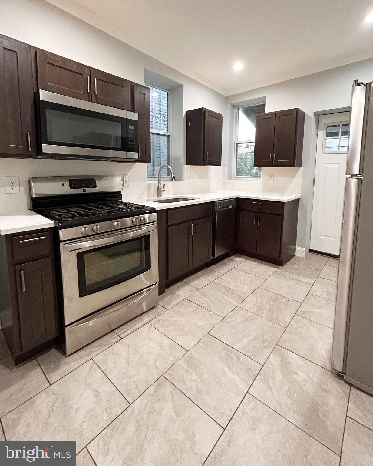 Welcome to this beautifully updated 3-bedroom, 2.5-bath home that perfectly blends modern upgrades with timeless character. Step onto the inviting front porch and into a warm, stylish interior featuring original exposed brick, recessed lighting, baseboard molding, and solid hardwood floors that add charm and personality to the living space. The upgraded kitchen is designed to impress with stainless steel appliances including a brand new 5-burner gas range and dishwasher, modern finishes, and plenty of cabinet space.  Head upstairs to find a generously sized primary bedroom with en suite bathroom. Two additional bedrooms and a hallway bathroom provide comfort and flexibility for today’s lifestyle. The finished basement adds valuable extra living space—perfect for a family room, home office, gym, or entertainment area. Out back, enjoy a private backyard ideal for relaxing, gardening, or summer gatherings. This move-in-ready home offers the perfect combination of character, comfort, and thoughtful updates.