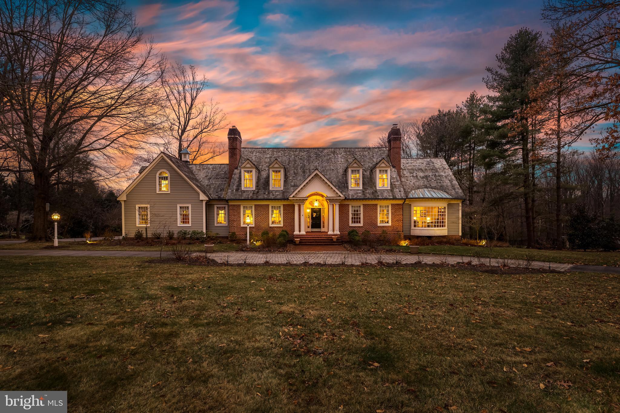 Nestled in the highly regarded Springhill Farm community along the Falls Road Corridor, 25 Springhill Farm Court is a custom-built Virginia Tidewater-style residence originally designed in 1989 by Benhoff Builders as his personal home.  Encompassing 7,166 square feet of living space,the property has been meticulously renovated and seamlessly expanded by the current owners this five-bedroom, four full and two half-bath property sprawls over 2.56 acres of professionally landscaped grounds and the home artfully blends classic architectural design with exceptional craftsmanship and comfort.

A barrel-vaulted portico leads into the vaulted two-story Foyer, where a curved oak staircase and raised-panel wainscoting set the tone for the rest of the home. To one side, the formal Living Room features hardwood floors and a fireplace framed by a paneled wall and black marble surround. Opposite, the Dining Room offers a warm, elegant setting with a fireplace flanked by custom cabinetry and marble serving counters. The richly paneled Library includes a full-width bowed bay window, fireplace, and custom cherry built-ins. The Family Room showcases vaulted ceilings with exposed rough-hewn beams, a brick fireplace, and custom cabinetry, flowing easily into a well-appointed wet bar and Kitchen.

The Kitchen was expanded by the original owners and later reimagined by the current owners with custom cabinetry, handmade ceramic tile flooring, quartzite and Sapele wood countertops, and professional-grade high-end appliances. A colonnade entry from the Foyer and direct connection to the Breakfast Room and Family Room allow for ease of movement and entertaining. The stunning Sunroom, also added during the expansion, features a vaulted ceiling with exposed wood trusses and windows on all sides, creating a year-round connection to the outdoors. A Laundry Room with dog wash station, custom Mudroom with a convenient Powder Room, and an oversized three-car Garage round out the main level.

Upstairs, the Primary Suite offers a tranquil retreat with hardwood flooring, built-in cabinetry, and a bay window seat. A custom-fitted two-zone Dressing Room features an island with quartz top, open and closed storage, and architectural detailing. The marble-clad Primary Bath includes a soaking tub, separate shower, and double vanity. Three additional bedrooms, all with hardwood floors and custom features, include ample closet space and access to two well-appointed renovated baths.

The finished Lower Level includes a spacious Recreation Room, a private fifth Bedroom with a built-in Murphy bed and bay window, and an Exercise Room with custom cabinetry and multiple windows. A newly added Media Room includes a bar and connects to the home’s lower patios. Additional spaces include a full bath and multiple access points to outdoor living areas.

Professionally landscaped by a certified Master Gardener, the picturesque 2.56-acre property features specimen trees, perennial gardens, and thoughtfully designed outdoor spaces. Multiple tiered patios, a firepit with curved stone seating, and a brick barrel-vaulted front porch all reflect the home’s timeless charm. 25 Springhill Farm Court is a rare opportunity to own a one-of-a-kind estate in one of the area's most sought-after locations.
