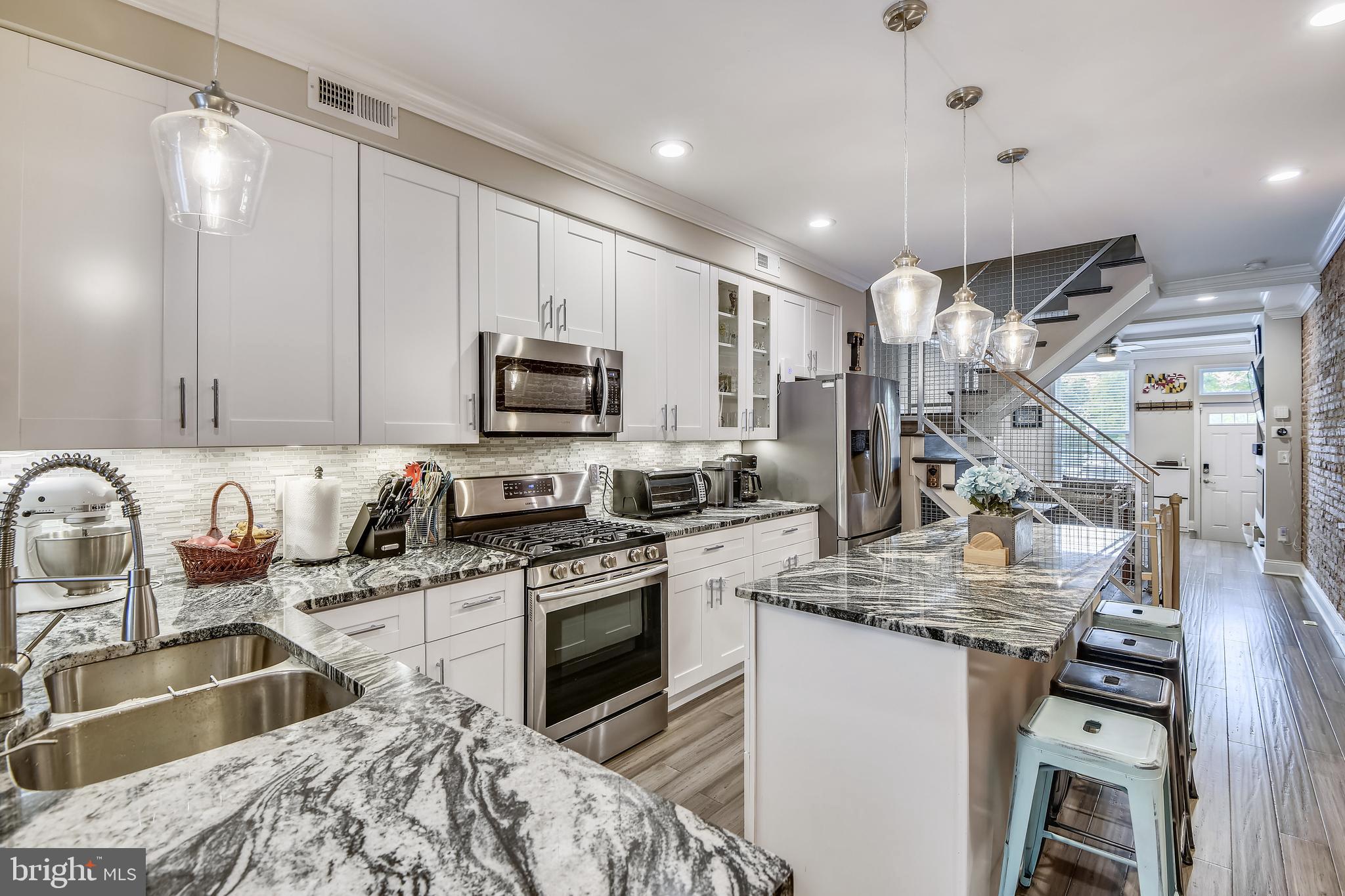 Incredible, newly renovated (2019), 4 bedroom, 3.5 bathroom with finished basement, rooftop deck, and fantastic water views located on one of the most desirable streets in Locust Point! This custom- built dream home boasts impeccable attention to detail-perfectly melding old world Baltimore charm with slick modern industrial finishes. Enter through the living room and find handscraped wide plank hardwood floors, coffered ceilings, and a sleek electric fireplace. The heart- of-home kitchen is gorgeous with white cabinets, oversized island, gas range, stainless appliances and the most stunning granite on the planet. The kitchen leads directly into the large dining area with dual pantries and a convenient 1/2 bath. Climb the custom staircase to the 2nd floor and find 2 large bedrooms, a bonus space that would make a great playroom, office or reading nook, and a gorgeous full bath with tub/shower combo and double vanities. The 3rd floor features a 4th bedroom and laundry room as well as the master bedroom with a bay window that frames exceptional city and water views, a gigantic walk in closet, and an incredible bathroom that could be featured on the pages of a design magazine. Travel up one more level and impress your friends on the full length rooftop deck with teak and turf outdoor flooring that is as functional as it is visually appealing and offers the best water and downtown skyline views on the whole peninsula! The basement is fully finished with a bonus room and full bathroom, as well as storage space. It would make a perfect home office, guest room or entertainment space. Also enjoy the convenience of dual zone smart nest thermostats and the security of the ring security system. Lowman Street is known for having easy angled in parking, a communal parking lot, and a warm neighborly feel. It is situated only 1/4 of mile from the McHenry Row shopping center and only 2 blocks from Latrobe park and Francis Scott Key School. Locust Point has become one of Baltimore City's most desirable neighborhoods- known as a quiet community surrounded by water but full of life and charm. There are quaint restaurants, excellent parks, sports fields, playgrounds, a dog park, Fort McHenry National Monument, waterfront promenade and offers free public transportation including the Charm City Circulator and Baltimore Water Taxi. Locust Point is home to major employers such as Under Armour, is close to  the University of Maryland, Johns Hopkins, Downtown Baltimore, and I95! Pets considered on case by case basis. View Virtual tour link for interactive floorplans!