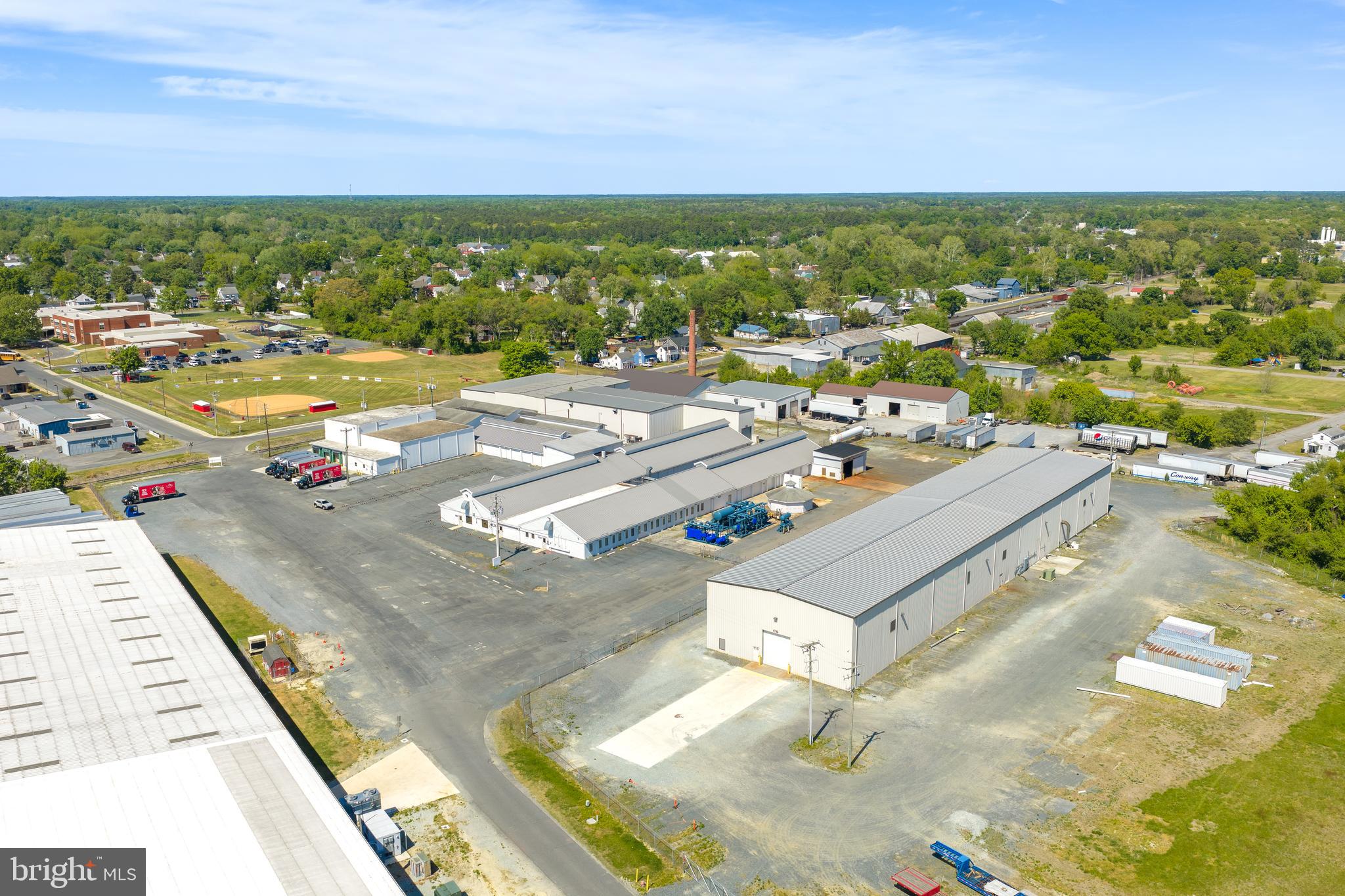 *LIST PRICE IS OPENING BID* Online Auction Only! Bidding begins Friday, June 5th, and ends Wednesday, June 10, 2026 at 1:00PM. 116,800+/- sq. ft. Industrial Complex on 7.93+/- acres in Federalsburg, MD **
This is a prime opportunity to acquire a three-building complex zoned ID-2, offering a mix of industrial warehouse and office space. The property is ideal for an owner-occupant or as an investment, with strong potential for rental income.
  
IMPROVEMENTS:
• Office–Manufacturing–Warehouse facility.
• 116,740 square foot total building area.  
• The property consists of 3 structures.
Structure 1: Approximately 93,340 square feet
This is the original building with some smaller associated outbuildings. This section comprises the two front office sections labeled “Building 1” and Building 2” on the attached site floor plans. These are connected at the rear to a variety of large manufacturing and warehousing areas. The ceiling height is approximately 30 feet at the roof line in most of the larger warehouse sections. There are also compressed air-lines serving these spaces but most of the compressors have been removed. This section contains a warehouse section leased to Glacier Point Enterprises, Inc. 

Structure 2: Approximately 23,400 square feet
This is the 325’ x 72’ 23,400 square foot metal building containing the 15-ton and 25-ton bridge cranes. The initial building was originally 150’ x 72’ feet with an additional 175’ x 72’ section added in 2009. The main overhead drive=in door is 14’ x 16’. Ceiling heights are 35 feet to the roof line and 25 feet to the bottom of the moving crane rails. A full set of “as built” engineering drawings for the 175’ x 72’ addition is building are available. There is also an engineering study available of the maximum crane rail capacity if a user wishes to upsize the crane capacity. There are multiple 480v 600 Amp 3 Phase panels serving this building.

Structure 3: Garage

Additional Property Details:
Parking lot:
• Truck/Trailer Parking Spaces: 6+/- 
• Car Parking Spaces: 50+/- 
• Total Parking Spaces: 56+/- 

Infrastructure
• ELECTRICAL INFRASTRUCTURE: The property is served by Delmarva Power. There are multiple electrical panels on site serving the various buildings and manufacturing areas. The primary industrial panels are 3 Phase 480/277 Volt - 1.200, 800, & 600 AMP services.
• DATA INFRASTRUCTURE: Dedicated Fiber connection up to 10 gigs per second. Current contracted service level 100 megabits up and down. Contact Comcast Business Account Manager• NATURAL GAS: A natural gas connection is provided from the street. Chesapeake Utilities is the utility provider. There is a large propane tank in the rear, but it has not been used for many years.
• WATER AND SEWER INFRASTRUCTURE: Pending receipt of data from Federalsburg Public Works for size of service connection from the street.

ROOF STATUS: The original building (Property Component 1) had a completely new roof installed in 2021 at a cost of $955,000. A detailed description of the work completed is available upon request.

ENVIRONMENTAL STATUS: Property has had a Phase 1 and Phase 2 Survey completed which was reviewed by the MDE (Maryland Department of the Environment). They have issued a letter of satisfaction with the property’s environmental condition dated 7/11/2023, which is available for review in the documents section

 Zoning: ID-2
• Purpose: "The purpose of this district is to provide for a wide variety of light manufacturing, fabricating, processing, wholesale distributing and warehousing uses appropriately located for access by major thorough fares or railroads. New residential development is excluded."
• Permitted uses:
"A building or land shall be used only for the following purposes, consisting of general industrial, warehousing, and storage uses,"....(for more de Note: Neighboring Parcel known as 412 Railro