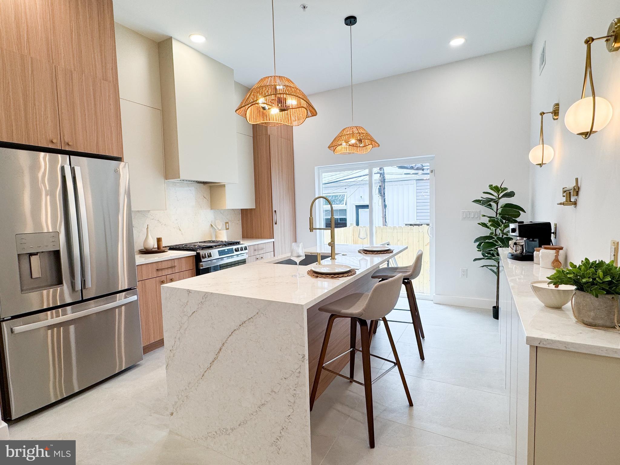 1711 N 4th St is here! — The response to sister property 1709 N 4th St was exceptional, going under contract in less than one week. Don’t miss your opportunity to tour this stunning new construction and make it your dream home before it’s gone! Thoughtfully designed and beautifully executed, this 4-bedroom, 3.5-bath residence blends modern luxury with warm, Scandinavian-inspired style. This home has a 10 year graduated tax abatement and 1 year builders warranty as well! From the moment you enter, you’re greeted by soaring ceilings and an open, airy layout that sets the tone for the rest of the home. Engineered hardwood floors run throughout, complemented by carefully curated lighting and high-end finishes at every turn. The chef’s kitchen is truly the centerpiece featuring sleek quartz countertops, a stunning waterfall island, premium GE appliances and a statement range hood. An additional breakfast bar with ample storage is thoughtfully outfitted with a pot filler to create the perfect coffee bar setup. Sliding glass doors flood the space with natural light and open seamlessly to the private backyard, creating the perfect indoor-outdoor flow. On the second floor, you’ll find two spacious bedrooms, each with ample closet space, built-in shelving, and beautifully designed en-suite bathrooms. One features a spa-like step-in shower with a built-in bench, while the other includes a tub/shower combination perfect for a nursery or flexible living needs. The entire third floor is dedicated to a luxurious primary suite retreat. This expansive space easily accommodates a king bed, sitting area, and boasts a large step-in closet. But the spa-inspired bathroom is the true showstopper! Featuring a massive step-in shower with a soaking tub, dual shower heads with handhelds, a wall-to-wall bench, and a beautifully appointed vanity it is truly a dream bathroom. Top it all off with a private roof deck offering 360-degree views of the beautiful Philadelphia skyline. The perfect place for entertaining or unwinding above the city. The fully finished basement offers a versatile fourth room, ideal for guests, a home office, or den along with a tiled living space and laundry area with washer and dryer. This Olde Kensington home is just a few blocks from Fishtown and is right near some of the best restaurants, breweries and coffee shops the area has to offer. Easily stroll to places like Human Robot, Rival Bros Coffee Bar, Jaffa Bar, and Kalaya (to name a few).