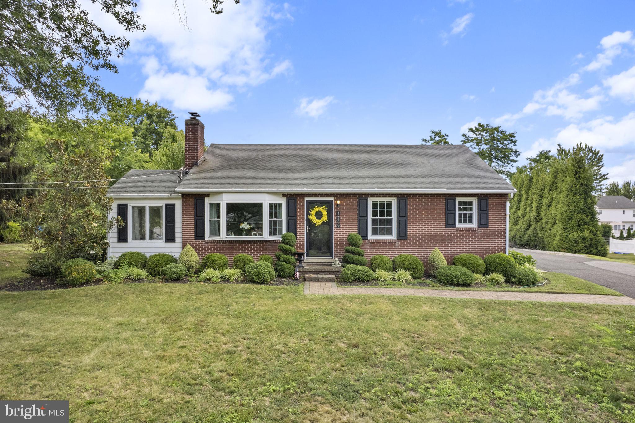 Welcome to 149 E. Linfield Trappe Road, a beautifully maintained brick ranch set on a picturesque half-acre lot with exceptional indoor and outdoor living spaces. From the moment you arrive, you'll appreciate the mature landscaping, expansive driveway, and inviting curb appeal.

Inside, the home offers a warm and welcoming layout featuring a bright living room with a charming whitewashed brick fireplace and large bay window that fills the space with natural light. The updated kitchen is the heart of the home, complete with custom woodwork, stainless steel appliances, stylish backsplash, and a spacious dining area perfect for everyday living and entertaining.

The main level also features three comfortable bedrooms, an updated full bathroom, and a versatile sunroom that can easily serve as a home office, sitting room, or play area.

The finished lower level provides incredible flexibility with multiple living spaces, a second kitchenette, and a beautifully updated full bathroom. With its private exterior entrance, this level offers excellent potential for an in-law suite, guest quarters, or multi-generational living arrangement.

Additional highlights include hardwood flooring, replacement windows and doors, abundant storage space, a walk-up attic, and a detached two-car brick garage with attic storage.

Step outside and discover your own private retreat. The custom paver patio is truly an entertainer's dream, featuring extensive hardscaping, low-voltage lighting, built-in seating, and a stunning raised stone fireplace—perfect for relaxing evenings and gatherings with family and friends.

Conveniently located near shopping, dining, parks, and major commuter routes, this move-in ready home offers the perfect blend of comfort, character, and versatility.