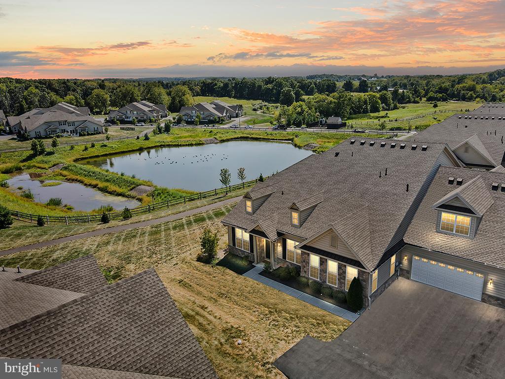 Wow! Imagine waking up to these views! Discover the perfect blend of modern luxury and serene natural beauty in this stunning 5-year-old home in Regency at Hilltown, nestled on a premium lot that backs up to a tranquil pond and open space. This beautifully maintained property offers a thoughtfully designed layout with elegant upgrades throughout. As you enter, you’re greeted by a foyer that flows into an expansive two-story living and dining room. The open staircase and soaring ceilings create an inviting atmosphere filled with natural light. The office, now with a large closet, can also serve as an additional bedroom. The gourmet kitchen is a chef’s dream, featuring an island, upgraded cabinets, premium countertops, and a well-appointed pantry. The kitchen also boasts top-of-the-line KitchenAid appliances and a stylish sink with an upgraded faucet. The cozy family room is filled with natural light and features a fireplace with an upgraded surround. It seamlessly opens to the kitchen and breakfast area, offering a fantastic layout perfect for entertaining. The 1st-floor master suite is a luxurious retreat with a tray ceiling, dual walk-in closets, and a spa-like bath. Relax in the Roman tub or enjoy the separate frameless shower with a seat, complemented by a dual-sink vanity and private toilet area. Upstairs, you’ll find a versatile loft with a vaulted ceiling that overlooks the living/dining room. This level also features additional 2 bedrooms and a full bathroom, providing ample space for family and guests. Convenience is key with a first-floor laundry room, a powder room, LVP flooring, upgraded carpeting, recessed lighting throughout and a 2-car garage. This beautiful home is located in Regency at Hilltown, a premier 55+ community! Enjoy top-notch amenities, including an 11,000 sq. ft. clubhouse with a state-of-the-art fitness center, outdoor pool, pickleball courts, tennis courts, bocce, and walking trails. With low-maintenance living provided, you’ll have more time to enjoy this vibrant community! This home offers a unique combination of luxurious upgrades and a picturesque setting. Don’t miss your chance to make this exceptional property your own!