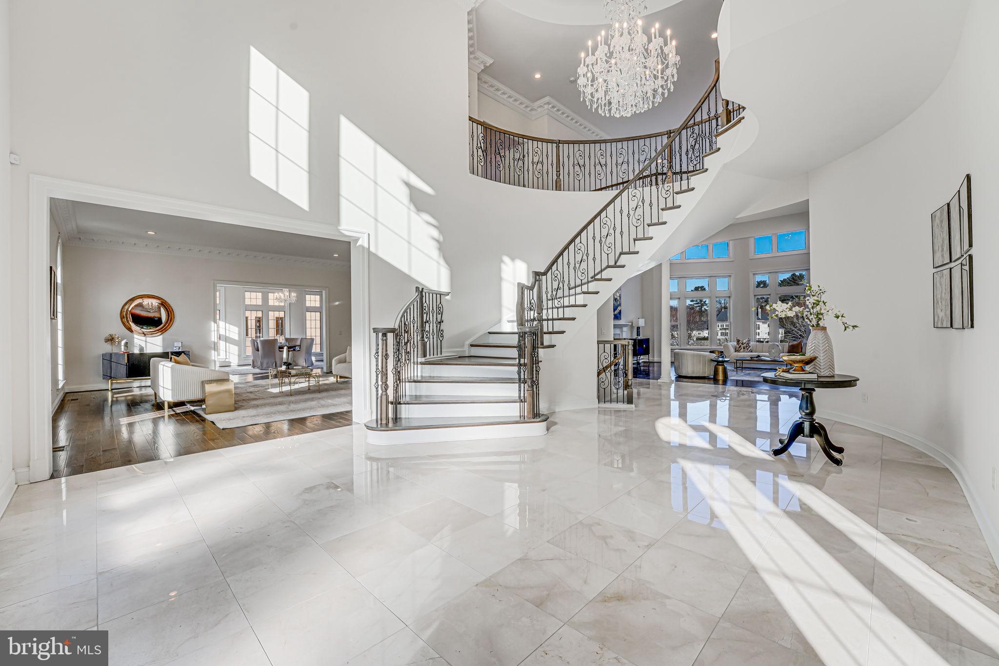 Welcome to this newly built premium custom home, perfectly positioned on a serene and private 5-acre lot in one of Great Falls’ finest neighborhoods. Overlooking a beautiful pond—with direct access for a variety of water activities—this one-of-a-kind residence offers sweeping views from nearly every room.

As you approach the property, the majestic Corinthian columns and expansive stone porch make a striking first impression. Upon entering, you are greeted by elegant Schonbek crystal chandeliers in the foyer and great room, where a pass-through view to the pond creates an inviting atmosphere.

The main level is designed for both sophisticated living and effortless entertaining. It features a grand great room with breathtaking exterior views, and a chef’s kitchen equipped with a high-end Thermador gas range and hood, Bosch double oven and dishwasher, and quality cabinetry—ideal for hosting formal gatherings or casual family meals. French doors open to a massive deck, perfect for grilling and outdoor dining.

Ascending via two custom staircases with finely designed iron handrails, you’ll find the luxurious upper retreat. The master suite offers a private sanctuary with an impressive dressing room and custom closet adjacent to a spa-like master bath featuring a luxury jetted tub and a separate shower with top-of-the-line Grohe components. Additional bedrooms and an apartment-sized room above the garage—with its own private bathroom—provide flexible space to suit your lifestyle.

The fully finished lower level boasts a walkout basement with 10-foot high ceilings, offering endless possibilities to create the perfect layout for your needs. Highlights include a wet bar, a media room ideal for gatherings, and a gym surrounded by mirrors.

Outside, indulge in resort-style amenities with a large gas-heated pool complete with an automatic cover and a professional-quality tennis court—a true rarity in residential properties.

This stunning home embodies refined elegance and modern sophistication, serving as the ultimate sanctuary and a rewarding retreat for those who have achieved the extraordinary.