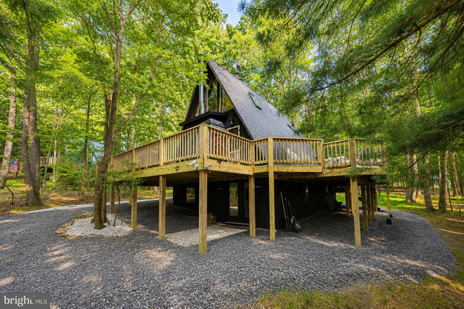Lake Access A-frame in the Sky Valley community at Deep Creek Lake. Owners here enjoy one of the lake's most desirable waterfront common areas, with a swim platform, kayak storage, and a community boat launch. Dock slips may be available through the HOA—ask for details.
Vaulted ceilings and natural light define the open main level, built for gathering. Four bedrooms and two baths give everyone room to spread out. A loft overlooks the living area and flexes as extra sleeping space, an office, or a quiet corner. The kitchen connects directly to the dining and living spaces. Outside, a hot tub, fire pit, and spacious deck sit in a private wooded setting.
Recent updates keep the home move-in ready: a whole-house water filter, replaced deck boards on the hot tub side, a new front door and porch light, fresh exterior paint, repaired roof flashing, and updated gravel around the house, pathway, and driveway. The basement bath was refreshed with new tile, vanity, faucet, and lighting.
Whether you want a full-time residence or a weekend getaway, this one puts you minutes from everything Deep Creek offers. Call today for details.