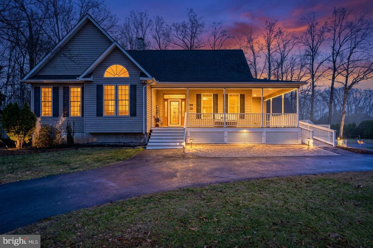 Experience Lake Anna public side living with an assigned boat slip at 25 Tara Woods Drive, an immaculate 4-bedroom, 3-bath lake access home with seasonal water views, perfectly positioned for summer lake season & immediate enjoyment. Ideal as a Lake Anna vacation home, short-term rental investment, or full-time residence, this property offers the space, layout, and features today’s buyers are actively seeking. The open-concept main level features vaulted ceilings, hardwood floors, and a stone fireplace, flowing into a spacious kitchen with abundant cabinetry and entertaining space. A main-level primary suite adds convenience, while additional main floor bedrooms and baths provide flexibility for guests and group stays. A screened porch with lake views and a wraparound front porch create multiple outdoor living spaces, highly desirable for both homeowners and vacation renters. The finished walk-out basement with partial kitchen, bedroom, full bath, and expansive recreation area delivers exceptional versatility—ideal for multi-generational living, guest suites, or maximizing short-term rental income. Walk directly onto the covered patio, extending the entertaining space outdoors. The backyard is designed for the Lake Anna lifestyle, featuring a fire pit area, kayak storage, shed, and room to gather after a day on the water. A standout feature is the detached 2-car garage with epoxy floors, insulated walls, and a commercial-grade lift, offering premium storage for boats, lake gear, and equipment. An accessibility ramp is already in place. Located just minutes from its assigned boat slip on Lake Anna’s public side, this home delivers what buyers want most: easy water access, strong rental potential, and move-in ready condition. Lake Anna homes with boat slips, finished basements, and investment potential are in high demand; schedule your showing now and secure your place for peak lake season.