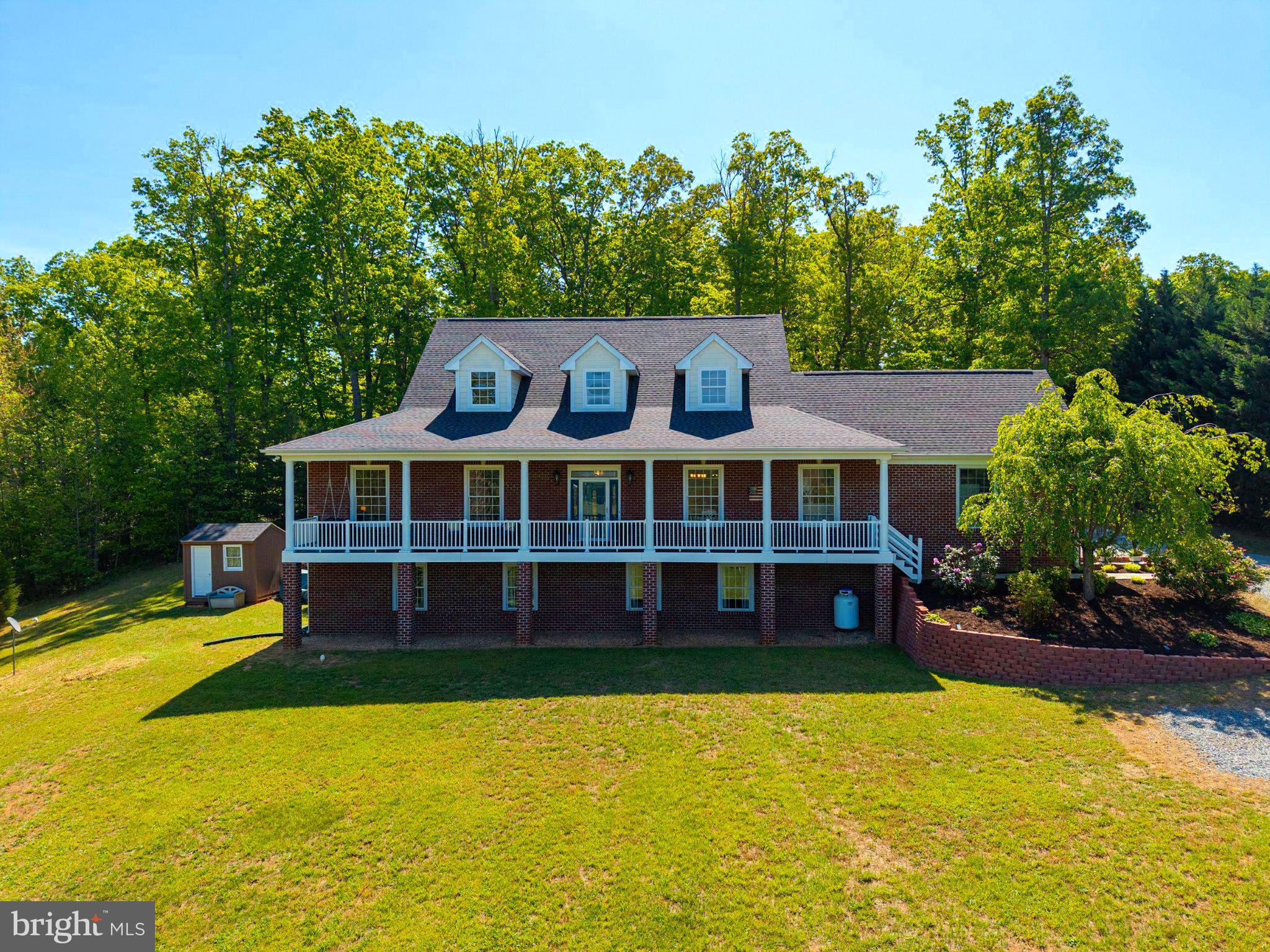 Meticulously maintained and custom built, this all-brick home offers timeless quality, refined craftsmanship, and breathtaking sunset views of the Blue Ridge Mountains from the inviting covered front porch. This thoughtfully designed home features 3 bedrooms, 3.5 baths, and a full walkout basement (2353 sq ft), combining elegance with everyday functionality. Inside, you will find Brazilian cherry hardwood floors, extensive custom crown molding, exposed beam accents, and transom windows above nearly every doorway, filling the home with natural light and architectural character. The gourmet kitchen is a true centerpiece, showcasing boxed beams, coffered and beadboard ceilings, granite countertops, stainless steel appliances, and handcrafted solid wood cabinetry, offering both beauty and durability. The walkout basement provides exceptional flexibility with radiant heat, a full bath, abundant storage, and a second washer and dryer, ideal for guests, extended living, or hobby space. Above the garage, an unfinished apartment or guest suite (1004 sq ft) presents incredible potential, already equipped with roughed-in electric, plumbing, HVAC, a separate panel, and full insulation, ready to be customized to suit your needs. Extensive recent updates include a new roof (April 2026), new HVAC system (May 2026), septic pump and inspection (April 2026), and full interior repainting (2025). Situated on two lots totaling over two acres, the property offers both privacy and space to enjoy, with a backyard that serves as a true retreat featuring mature landscaping and a custom slate patio, perfect for relaxing or entertaining. Conveniently located near Route 33, shopping, dining, the Shenandoah National Park, and local wineries, this move-in ready home offers a rare combination of enduring construction, thoughtful updates, and scenic lifestyle appeal.